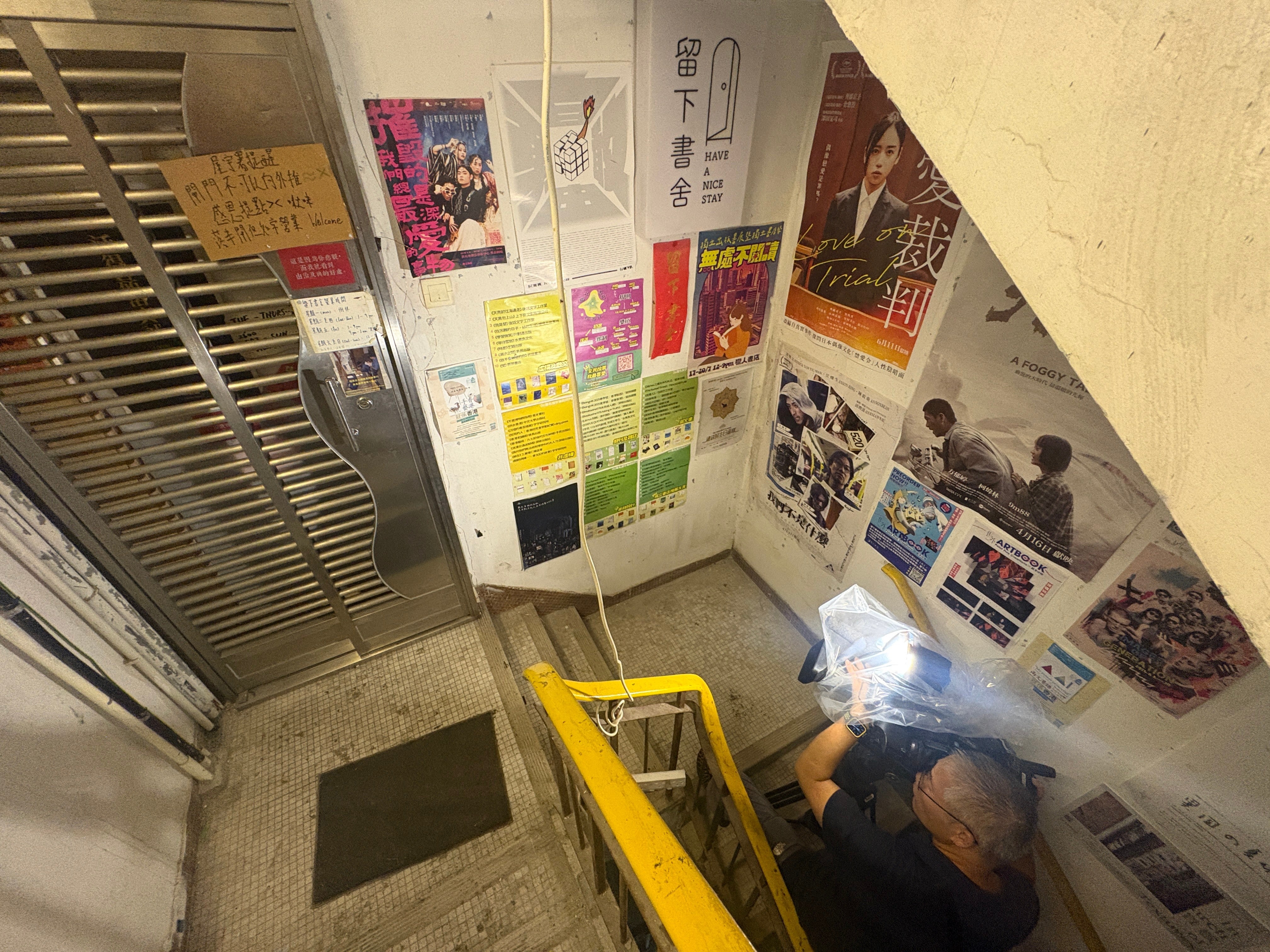 A journalist films the exteriors of the bookstore 'Have A Nice Stay' in Prince Edward district, Hong Kong, Wednesday (Copyright 2026 The Associated Press. All rights reserved.)