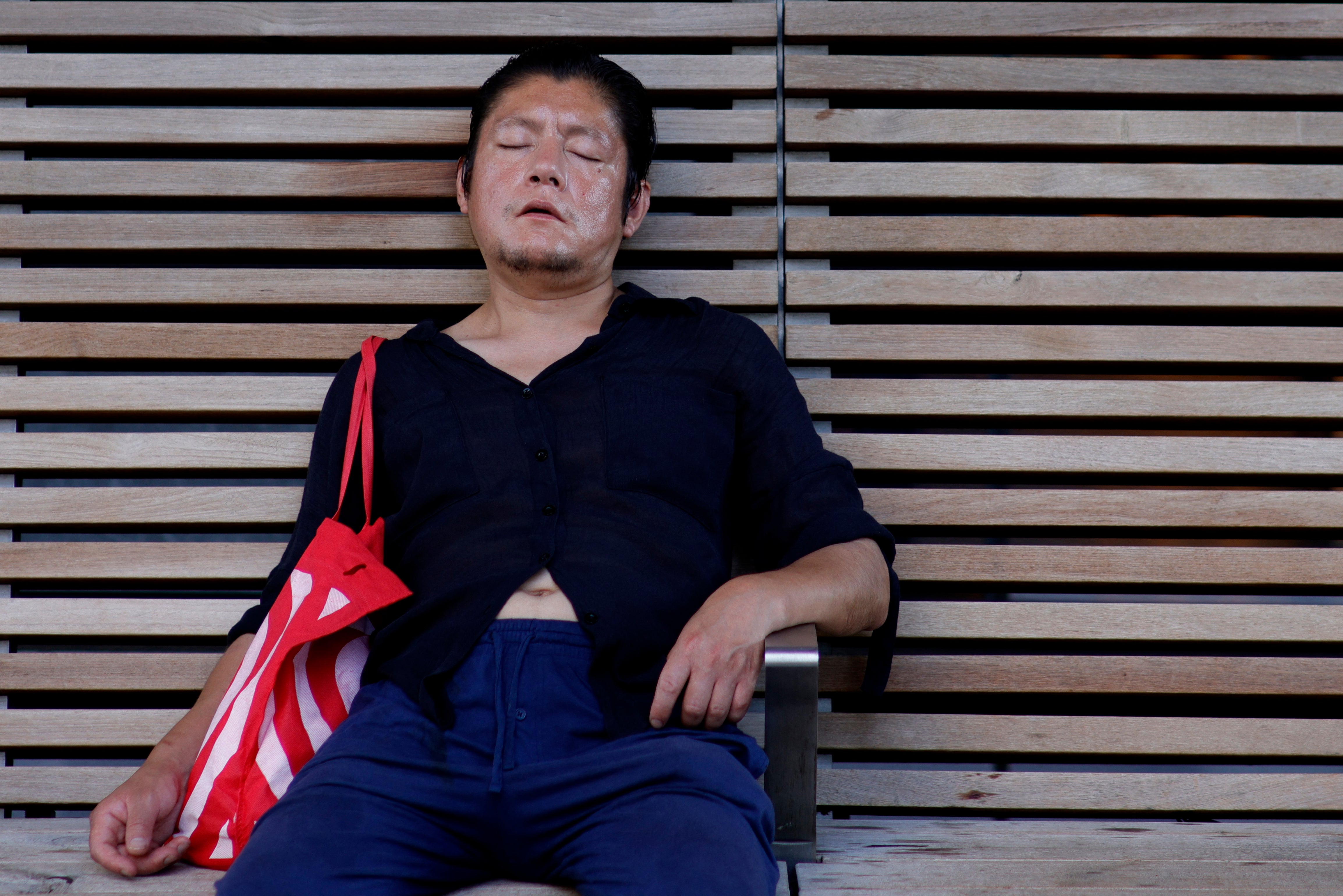 A man rests in the shade on a bench in New York City during this month’s heatwave. Experts recommend more negative or neutral images to tell stories about heat and climate change