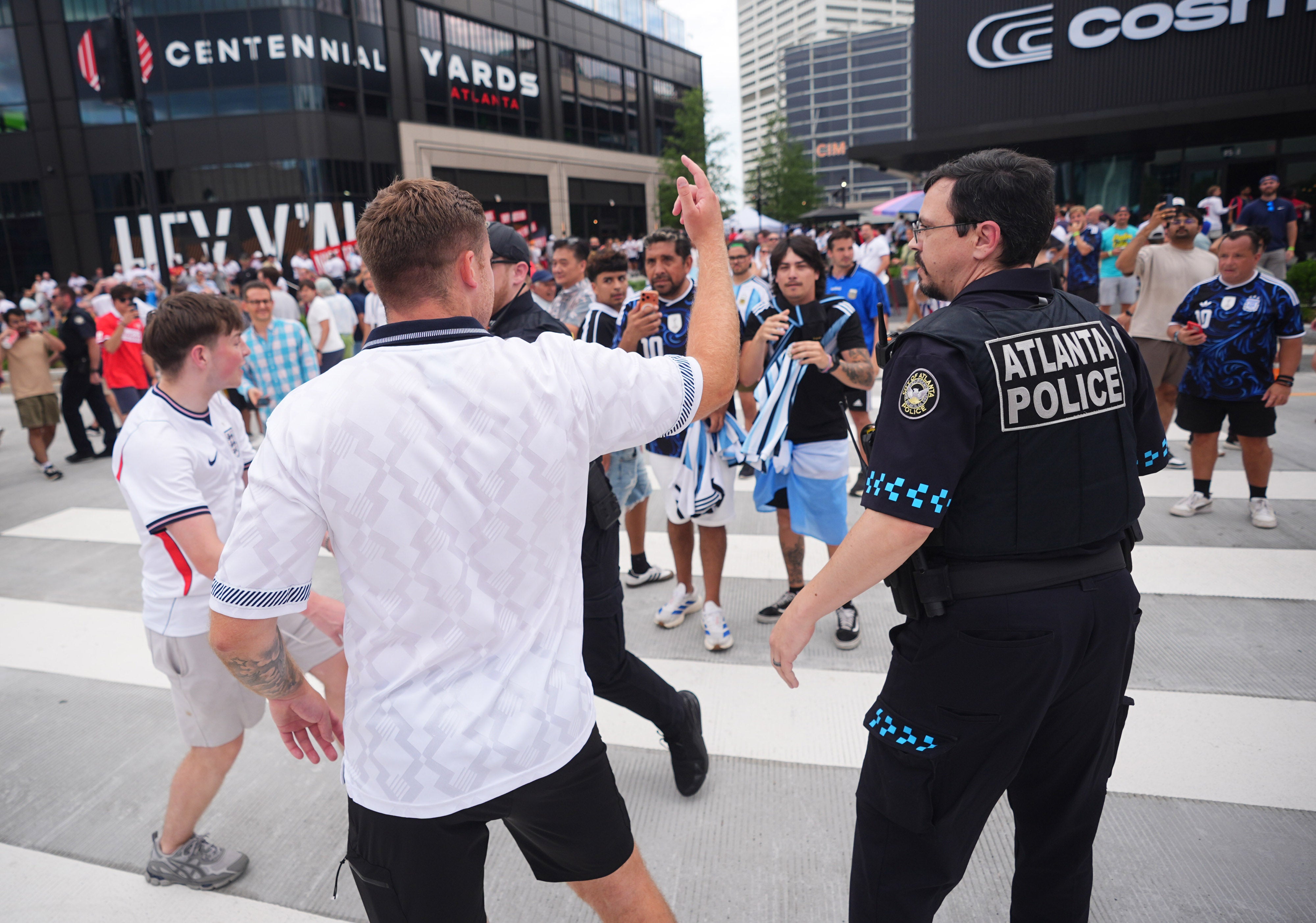 A police officer breaks up an argument between Argentina and England supporters as they leave the Atlanta Stadium