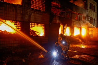 Firefighters work at a compound of a private enterprise damaged during Russian missile strikes, amid Russia's attack on Ukraine, in Kyiv