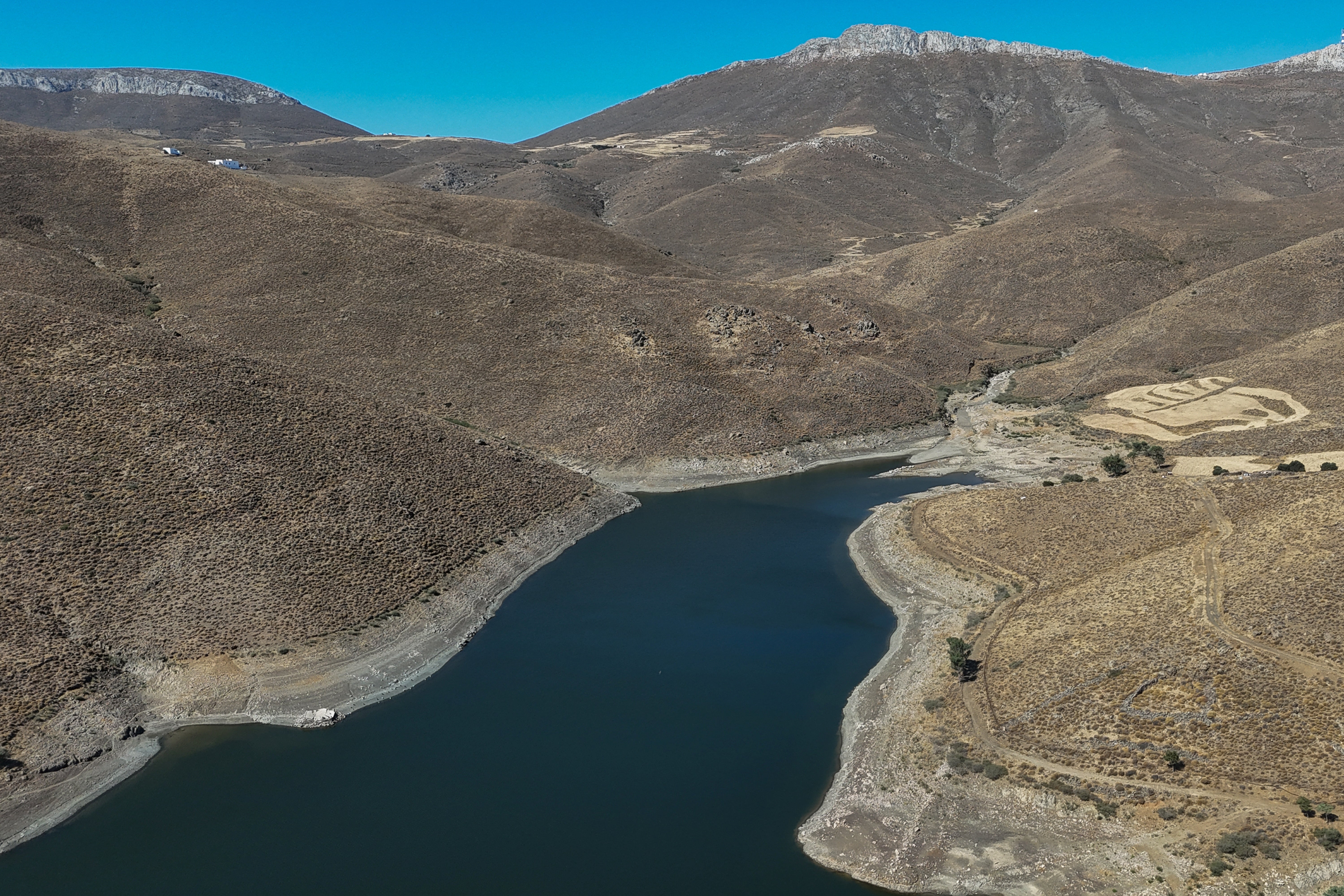 A drone view of a man-made lake, the island's sole water reservoir, currently containing just a sixth of its storage capacity, near the village of Livadi on the island of Astypalaia, Greece, July 13, 2026