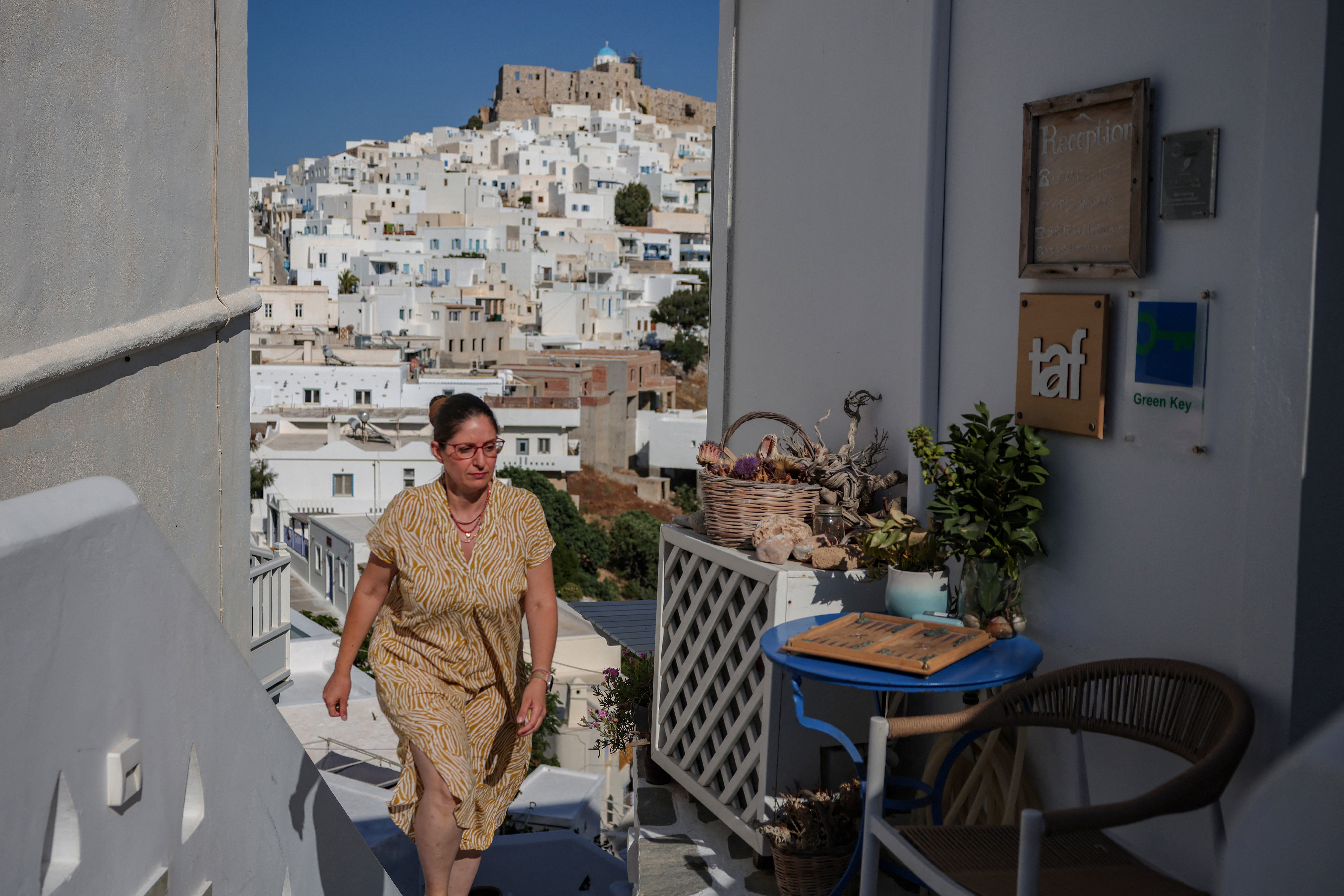 Maria Alkalai, 42, walks towards her hotel on a hillside, which offers a 5-euro voucher to guests who skip the daily cleaning service to save water, in Astypalaia, Greece