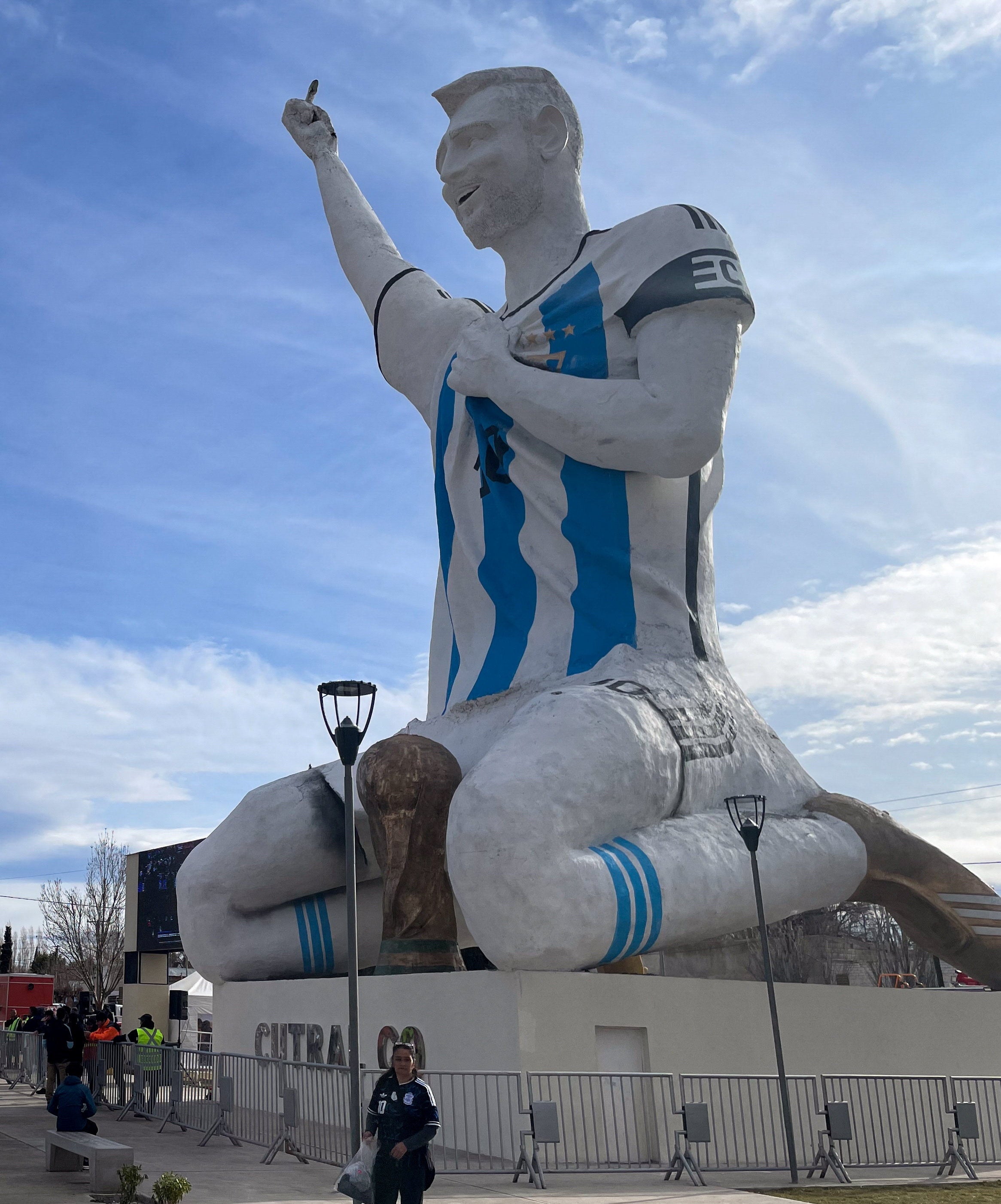 People gather by a statue of Argentina's revered Lionel Messi to watch the World Cup semi-final between Argentina and England, in Cutral Co, in the Patagonian province of Neuquen, Argentina