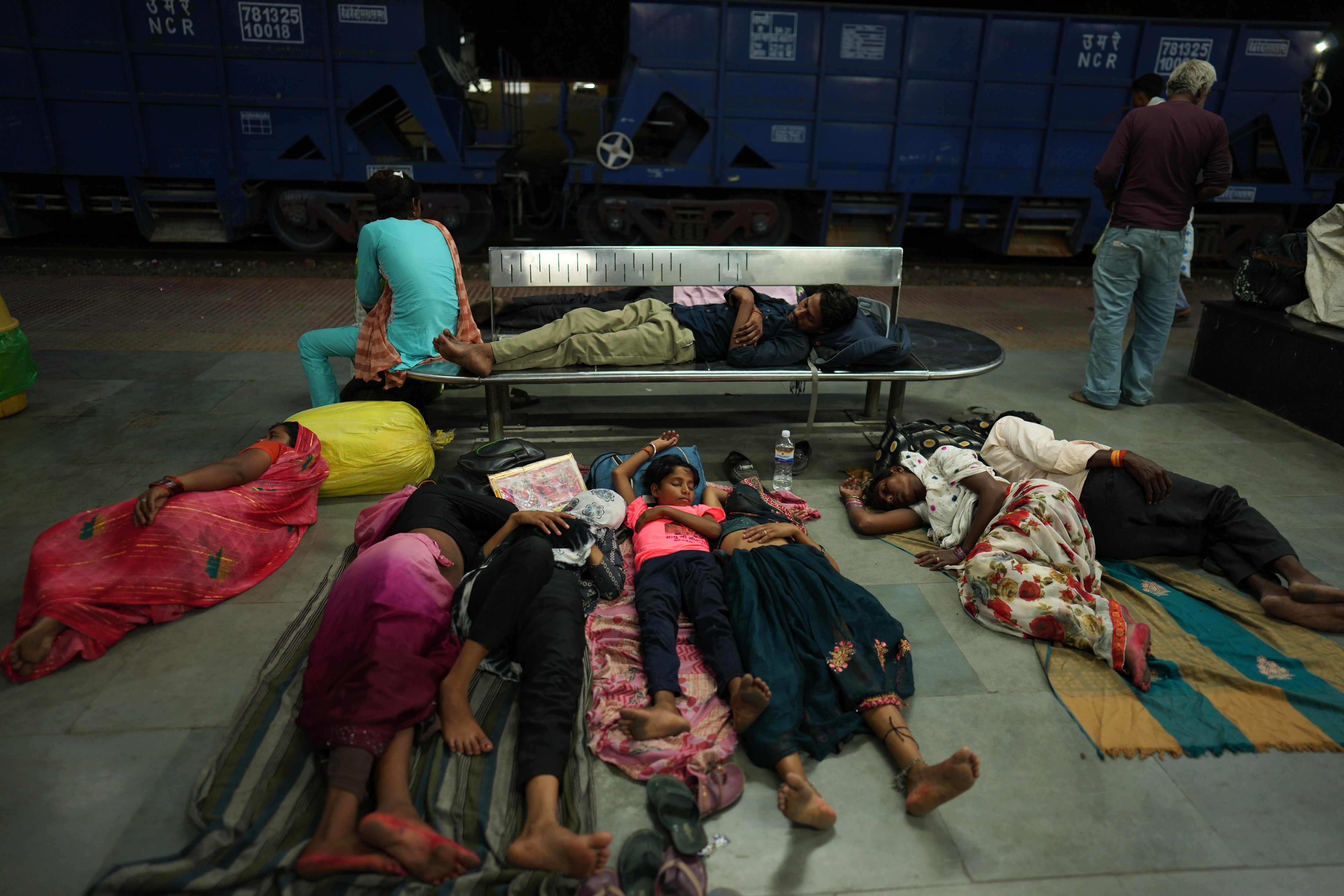 Residents sleep on the platform of a railway station to escape the heat in Banda, northern Indian state of Utter Pradesh, Saturday, June 20, 2026
