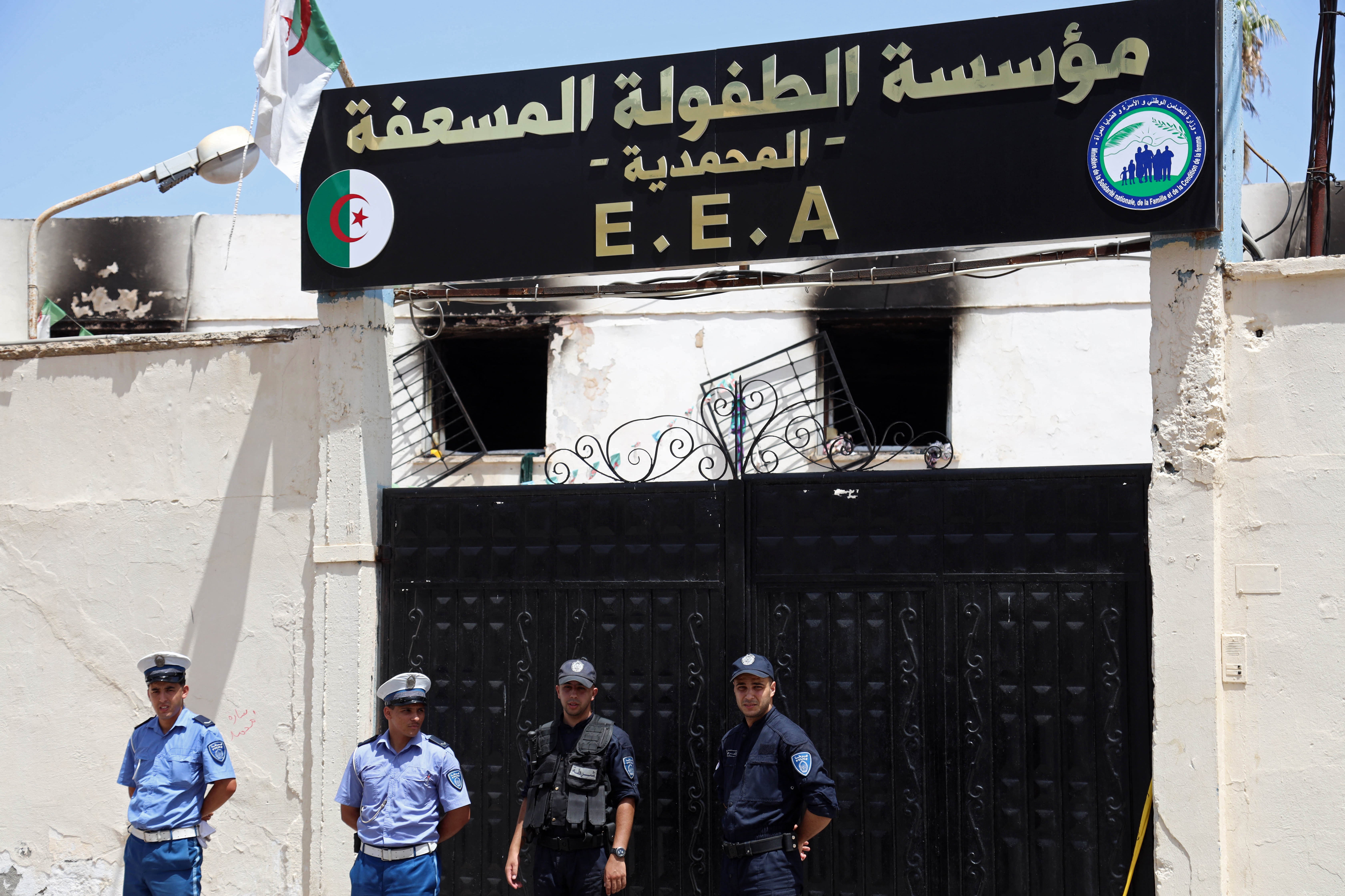 Police officers stand guard at the entrance of the orphanage in Algiers