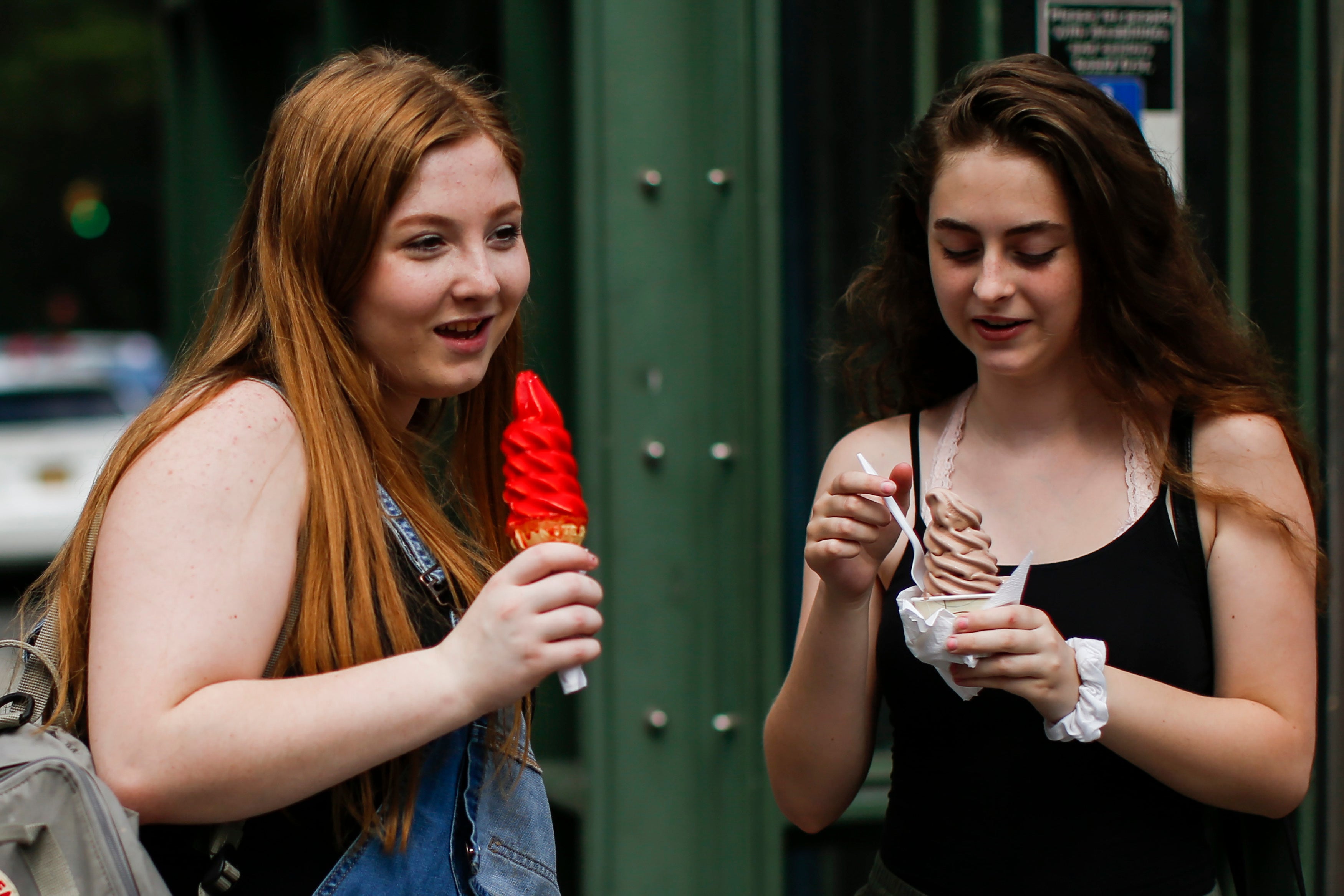 Women eat ice cream together in New York City’s Central Park in August 2018. Associating rising temperatures with positive feels could undermine the actual danger posed by heat