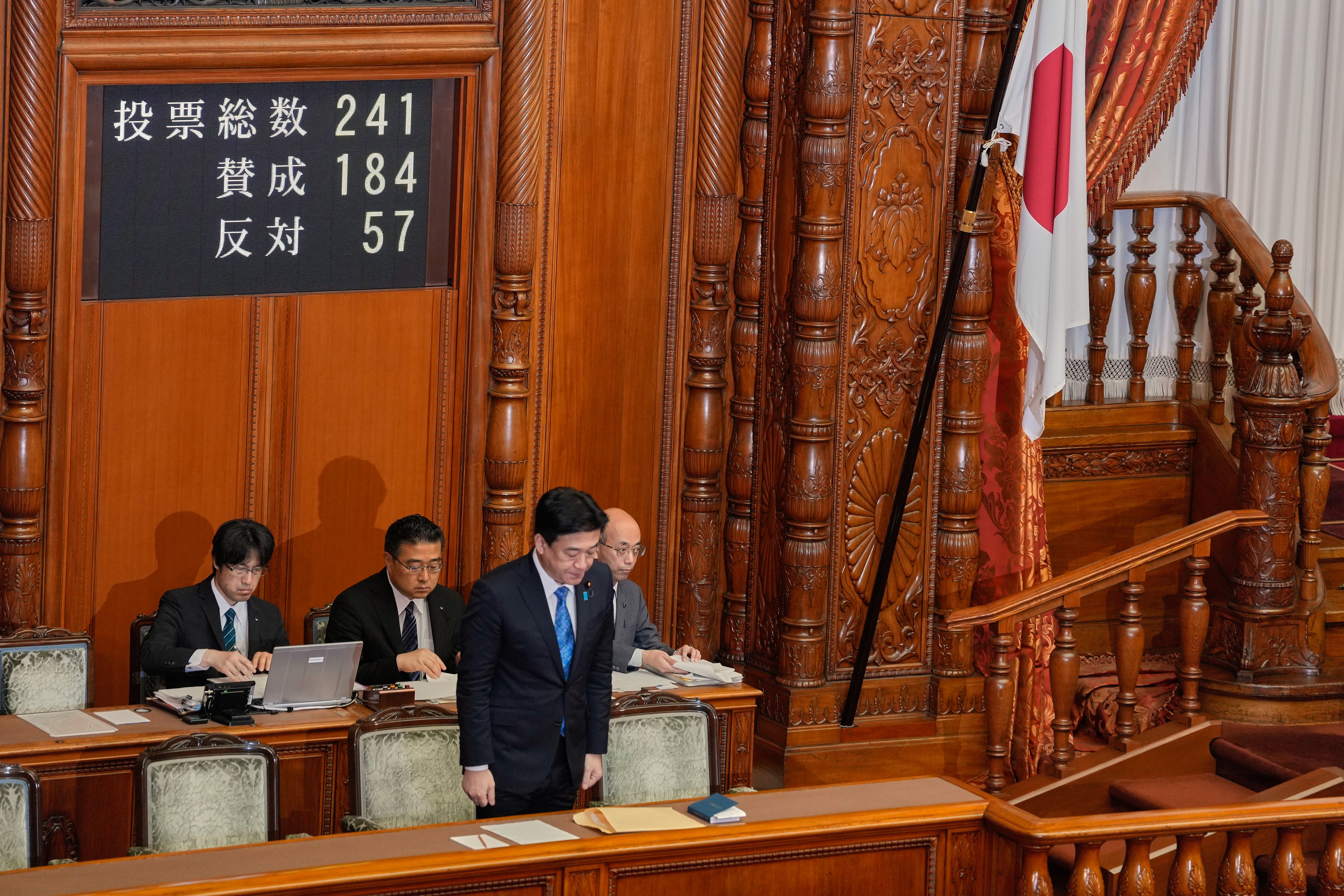 Japan's Chief Cabinet Secretary Minoru Kihara stands and bows after the Upper House passed a bill to revise the Imperial House Law