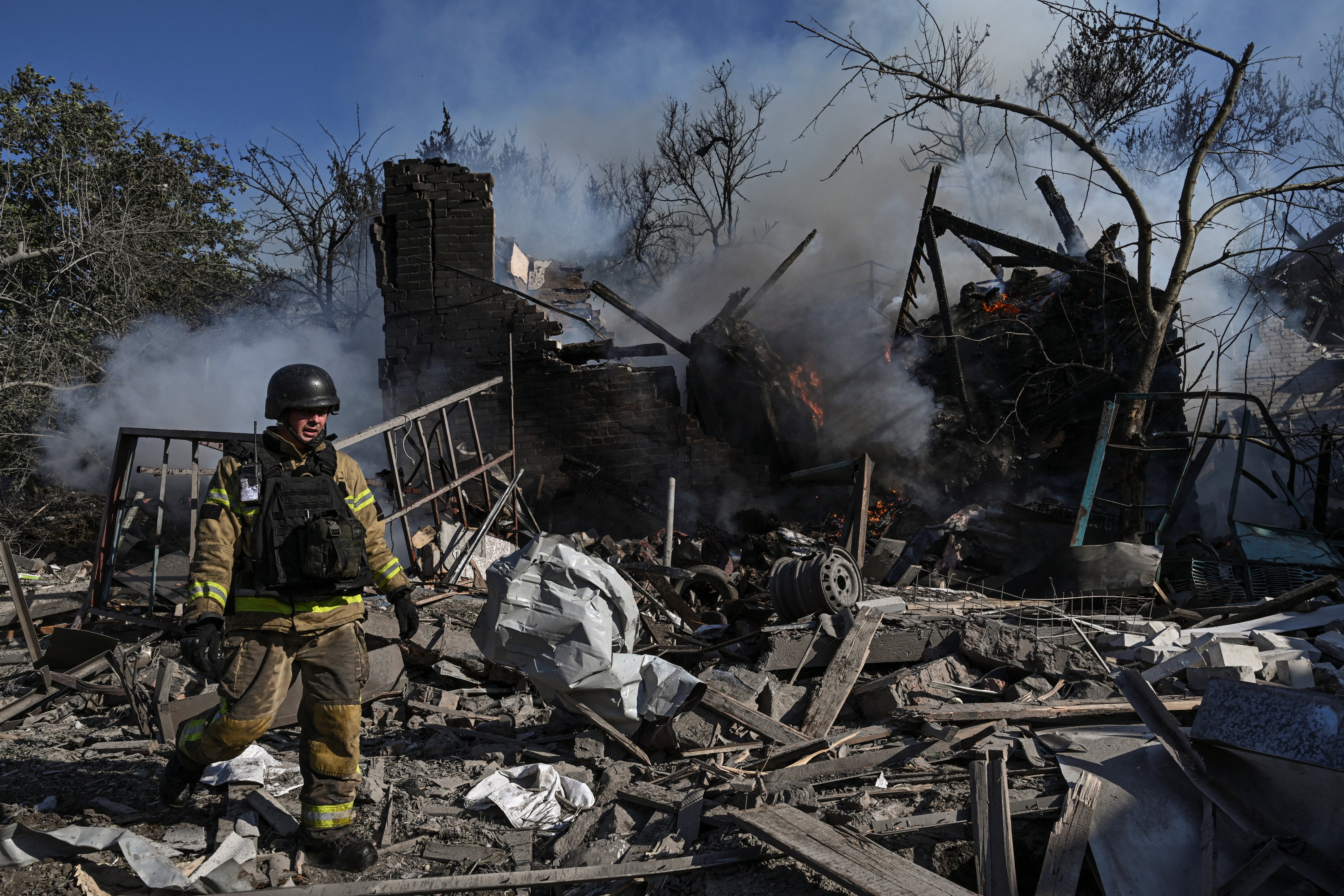A firefighter works at the site of a residential area hit by a Russian air strike in Zaporizhzhia