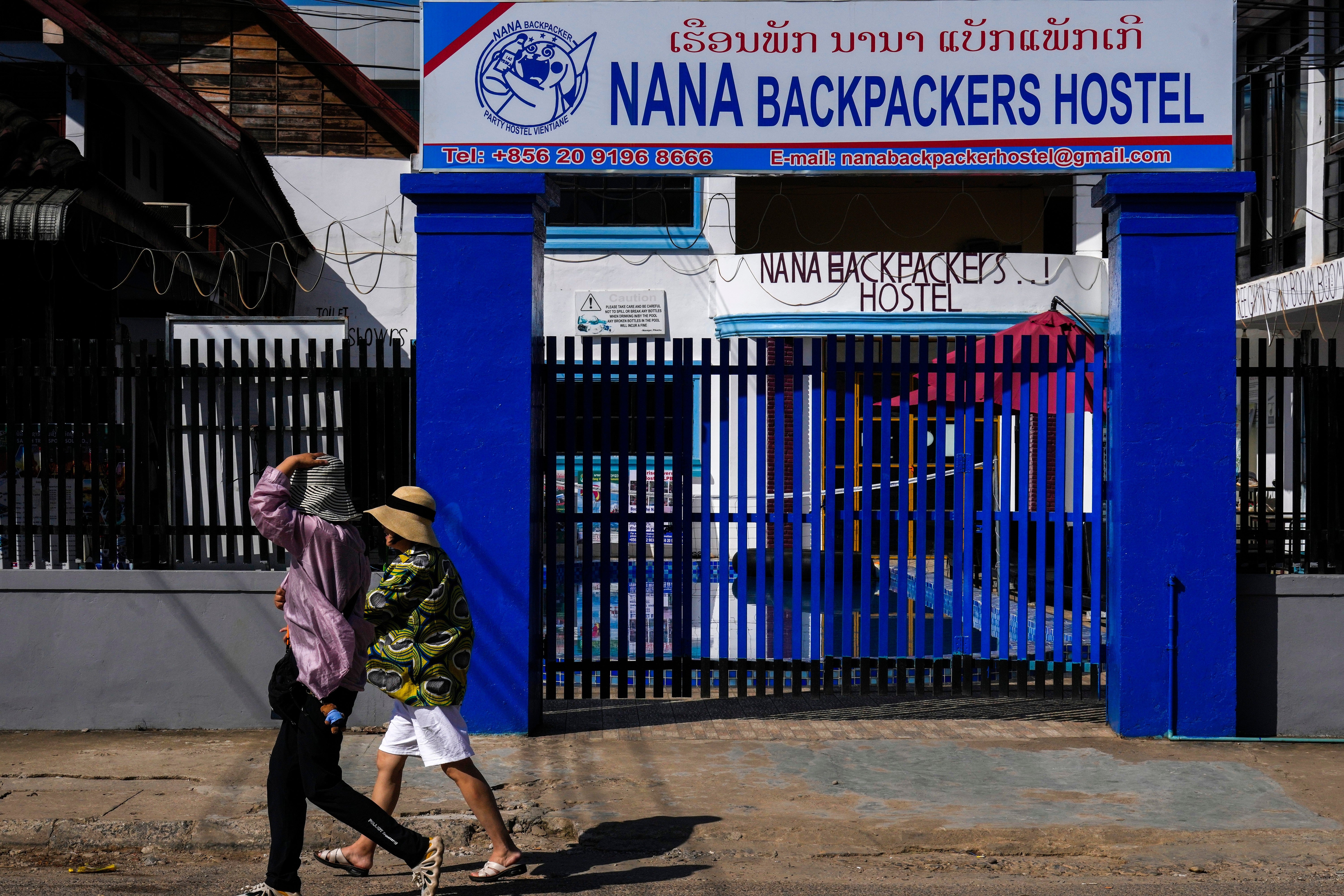 Tourists walk past the Nana Backpackers Hostel in Vang Vieng in Laos