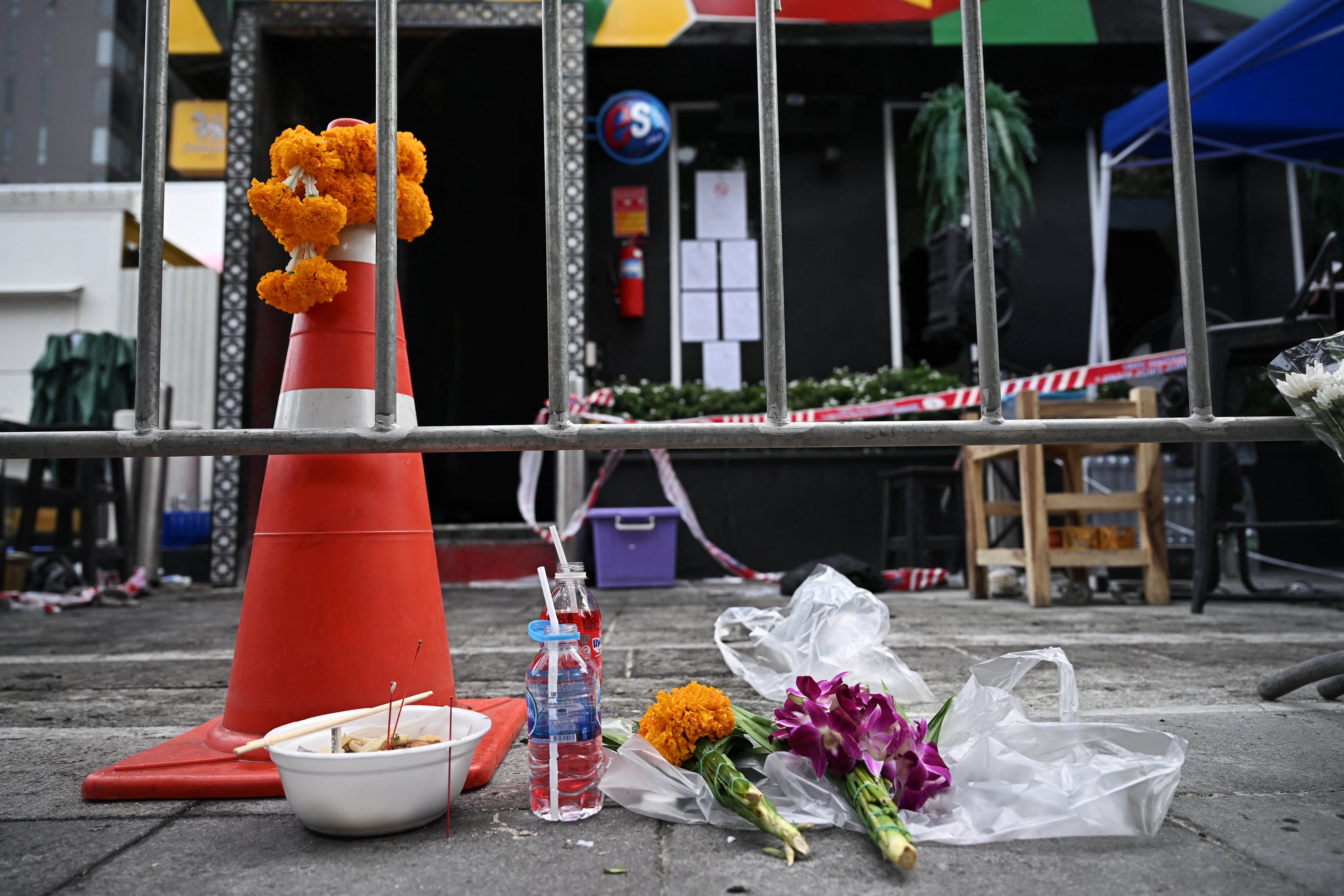 Flowers for victims in front of the Rong Beer Na Lat Phrao bar in Bangkok