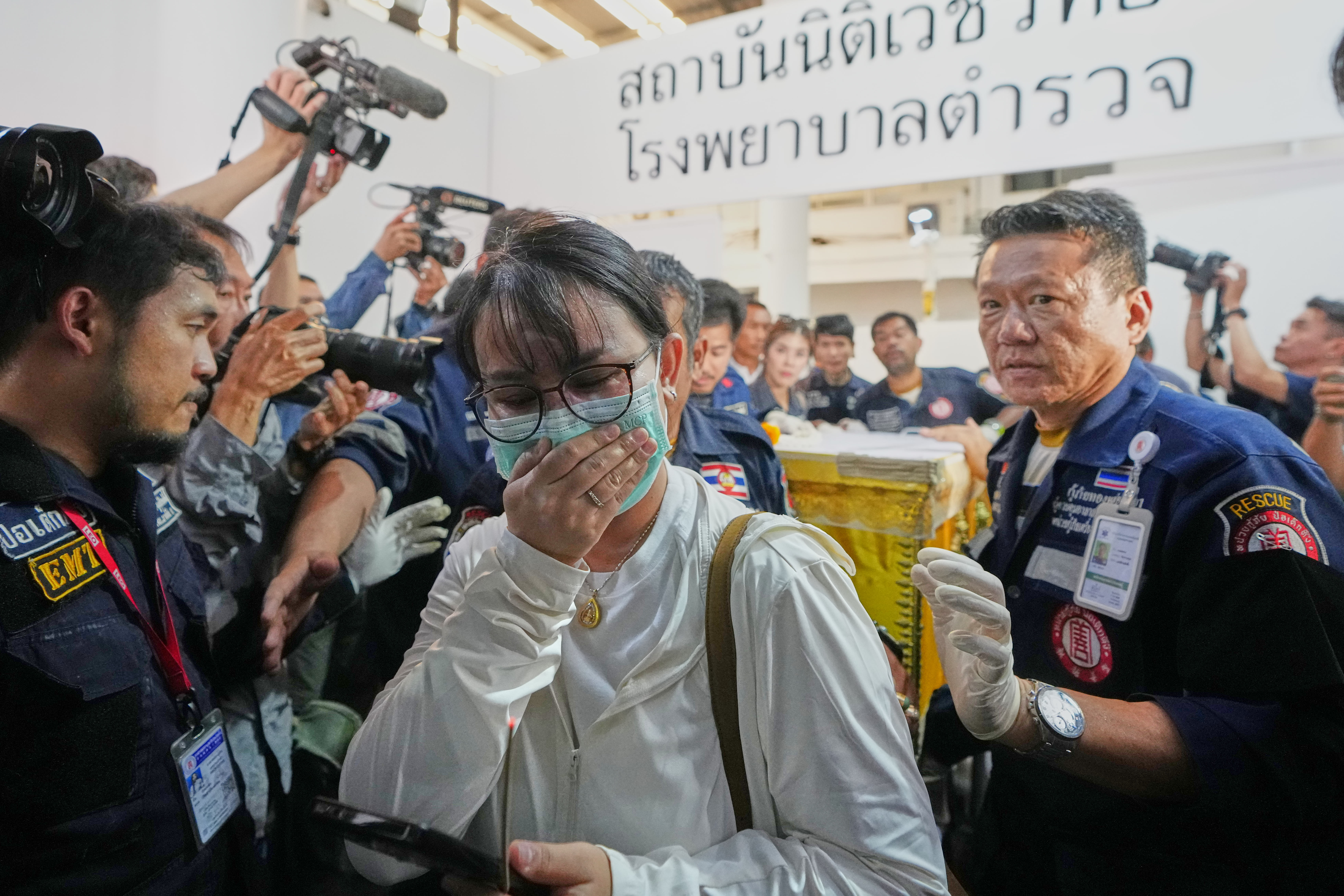 A coffin containing the body of a victim of the bar fire is transferred from a police hospital in Bangkok, Thailand