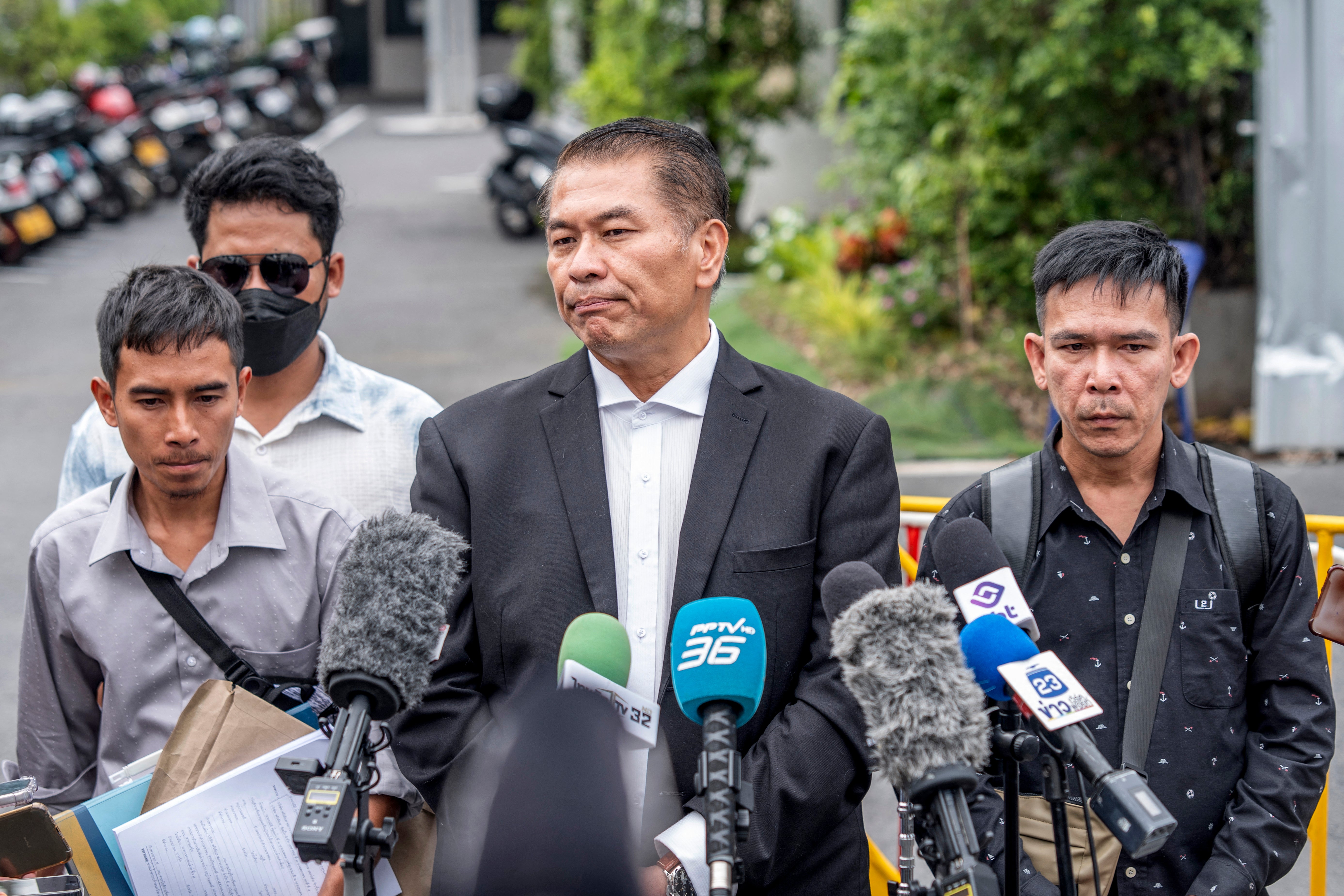 Thai lawyer Kunpat Singhathong (C) speaks to the media with three former sailors from the Thai-flagged ship Mayuree Naree outside the Central Labour Court in Bangkok on July 10, 2026.