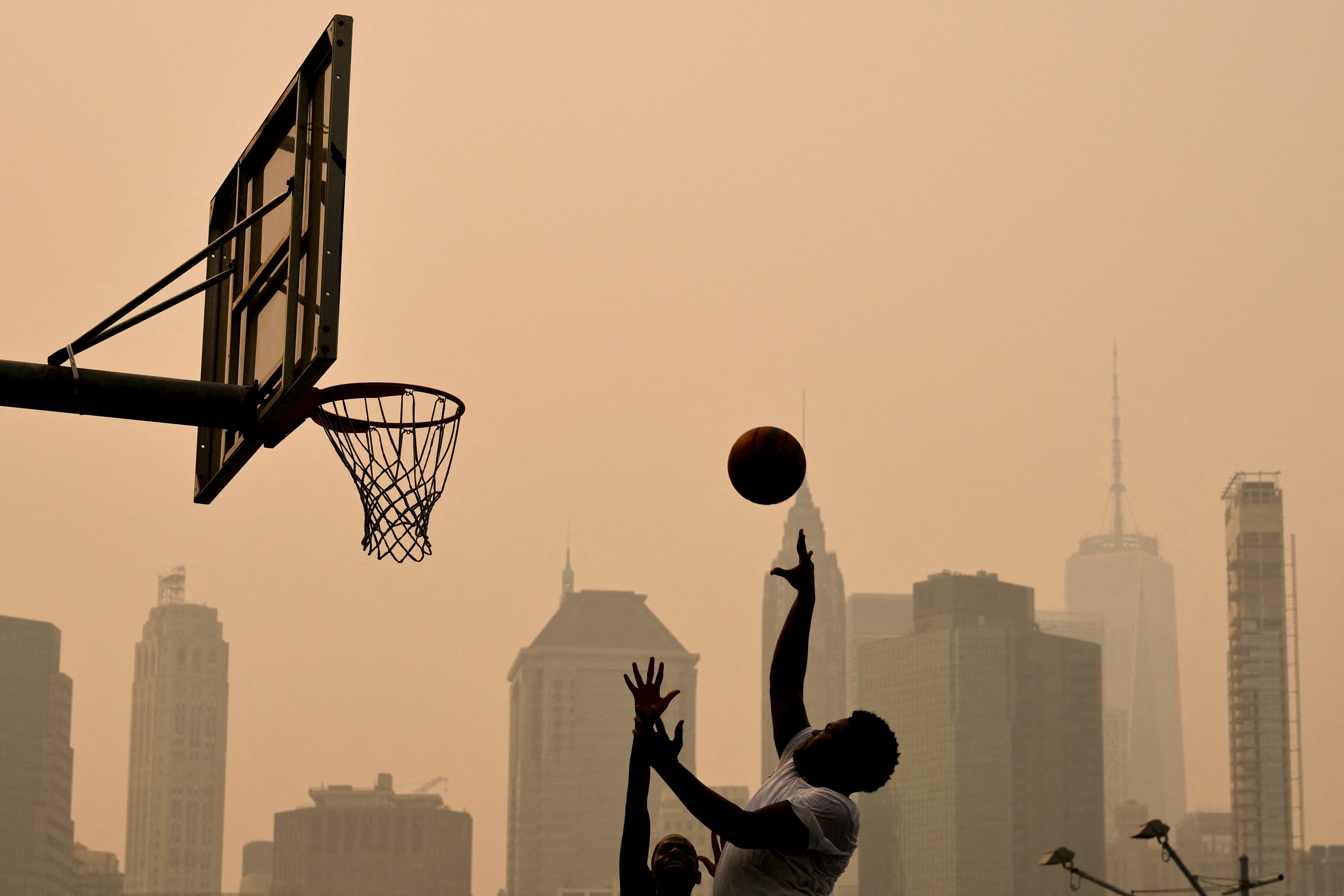 People play basketball Friday in New York City. Smoke can cause harmful inflammation that strains the heart