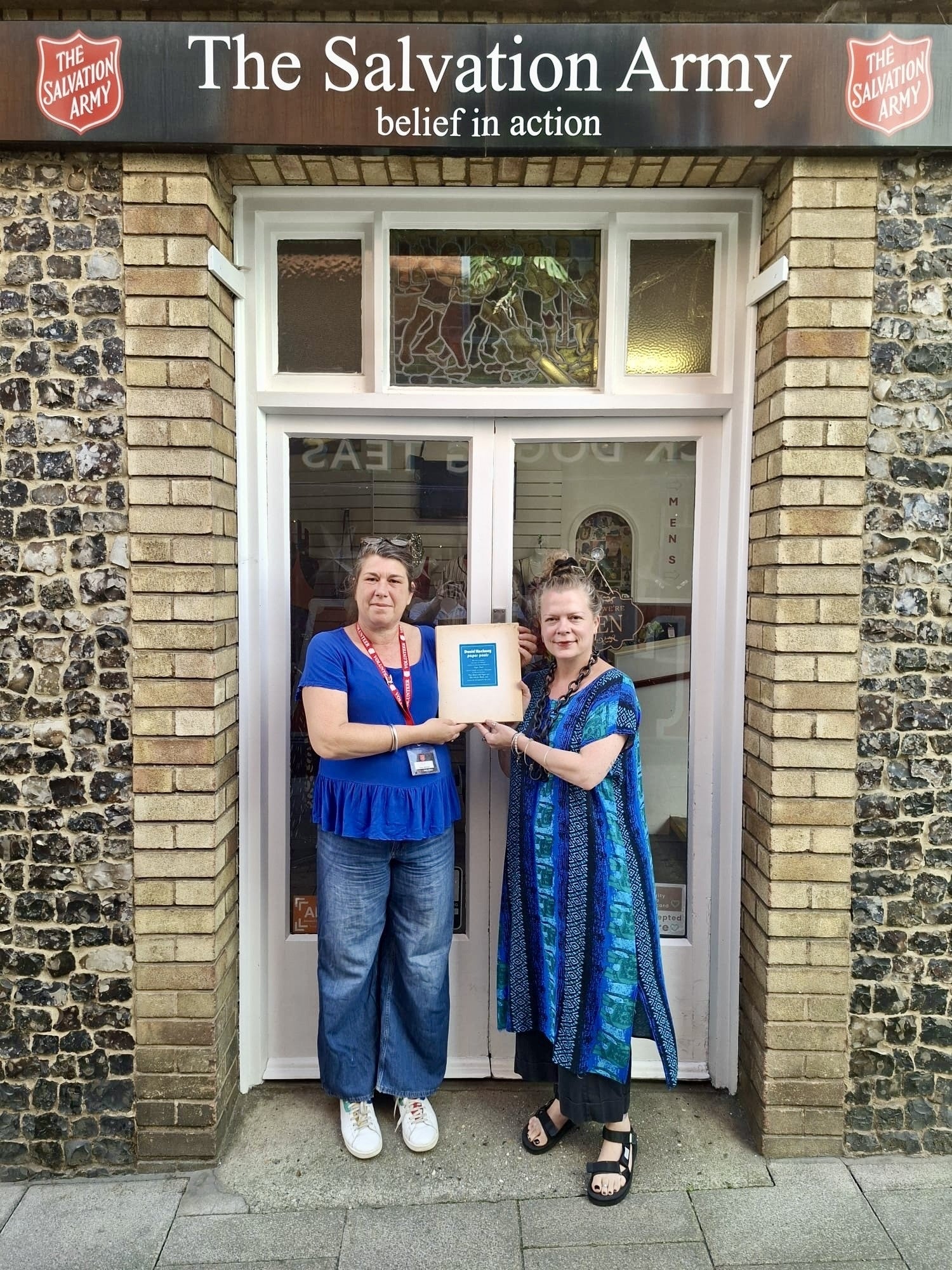 Jemma Banks and shop manager Maria Zacharias with the print and book (Salvation Army Trading Company)