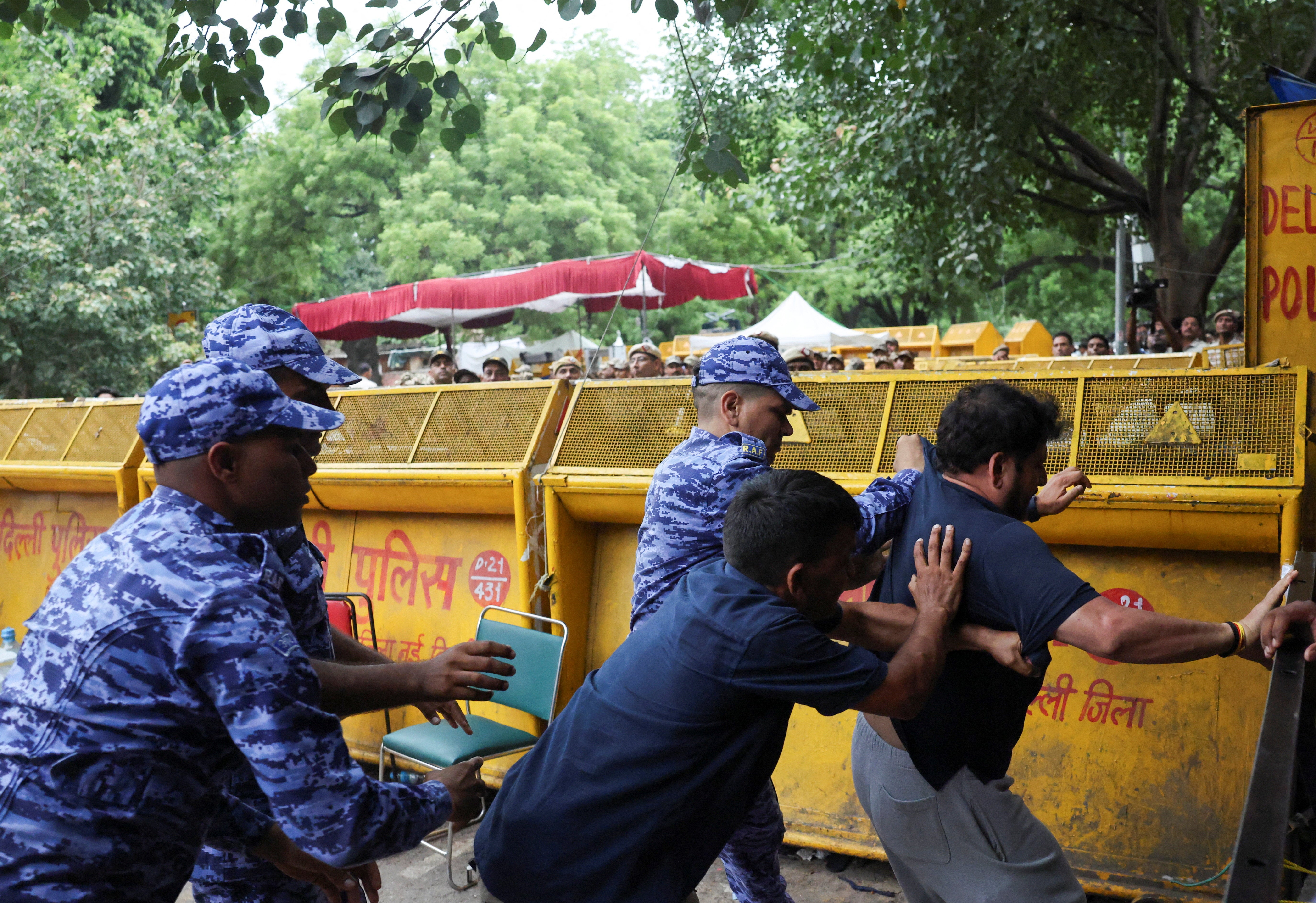 Members of the Indian security forces tussle with a supporter of Cockroach Janta Party (CJP) after authorities took Sonam Wangchuk, an Indian education reformer, who has been on hunger strike, to the hospital
