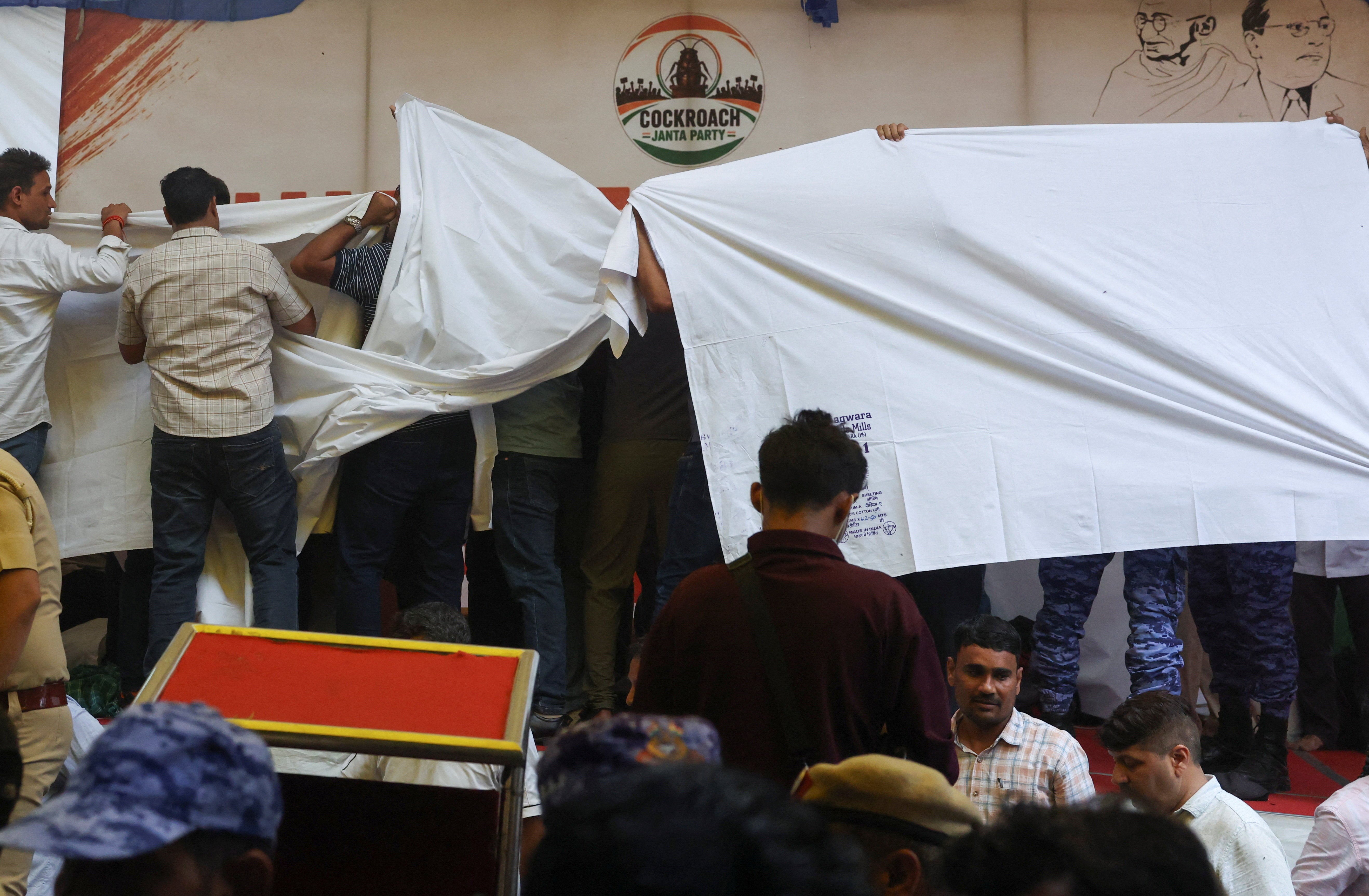 Authorities cover the stage with cloth as they prepare to take Sonam Wangchuk, an Indian education reformer who has been on hunger strike, to the hospital