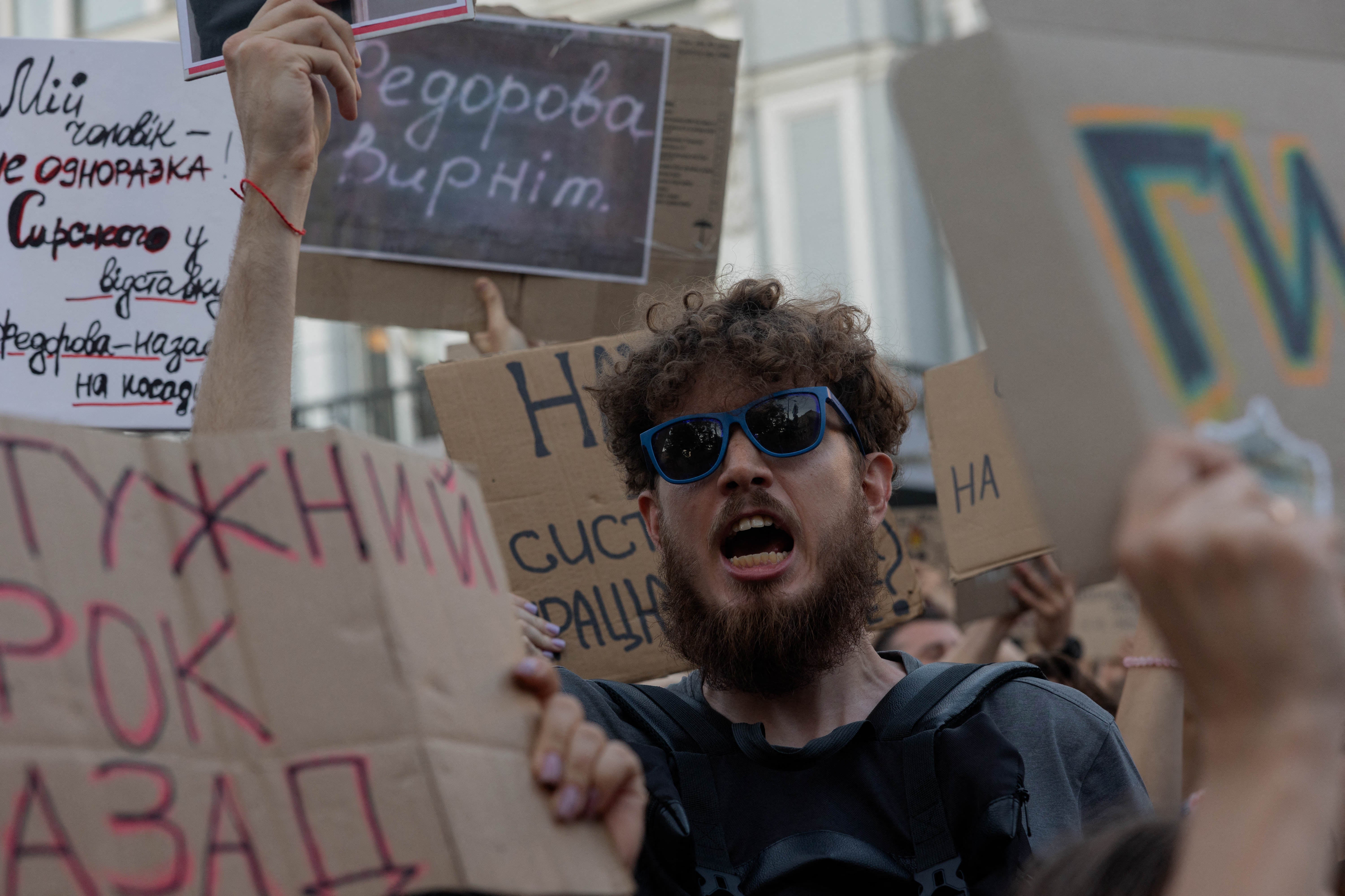 A protester holds a placard reading "Fedorov, return" during a demonstration against Ukraine's President Volodymyr Zelensky's decision to dismiss Ukraine's Defence Minister Mykhailo Fedorov
