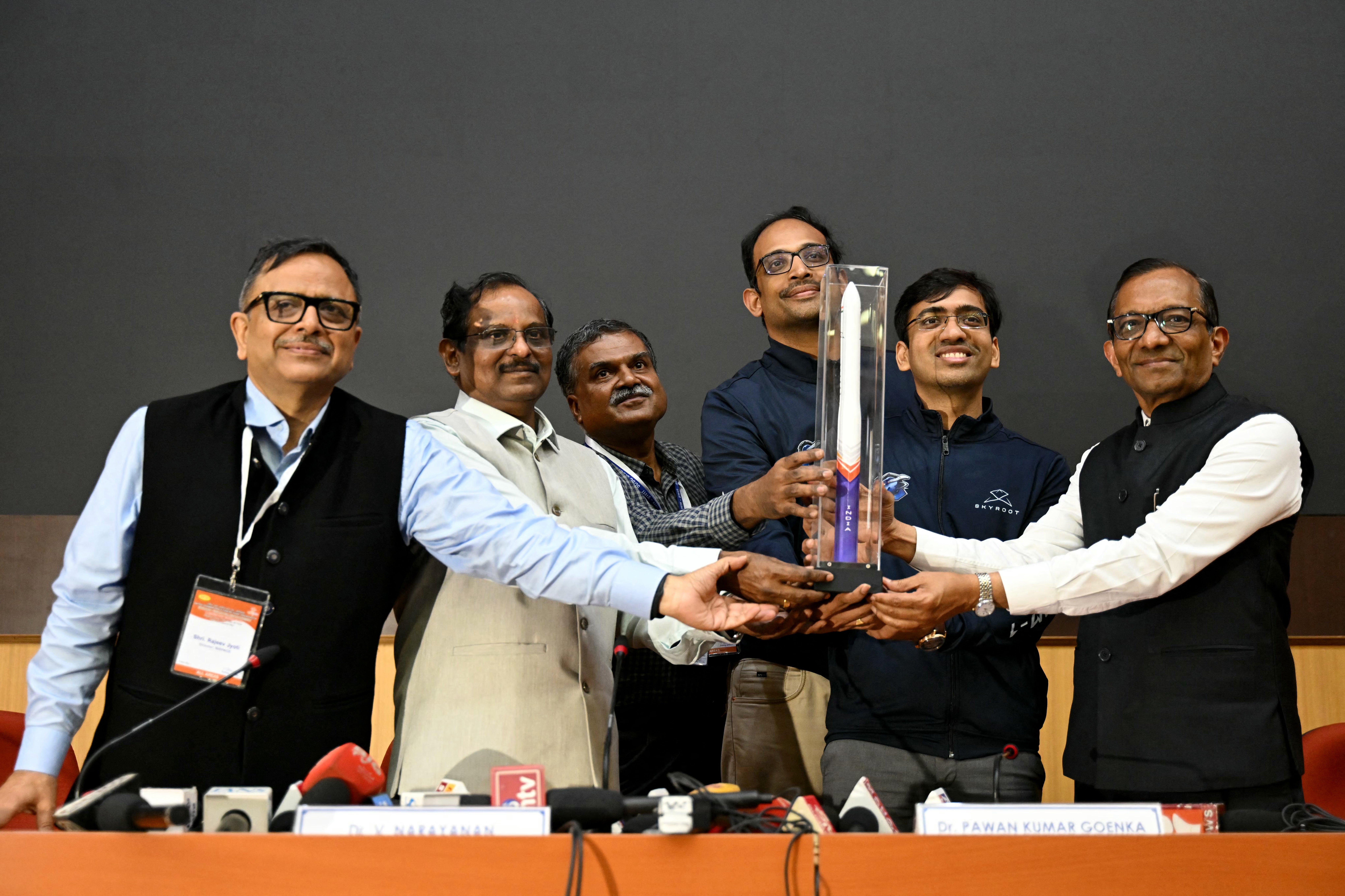 ISRO chairman V Narayanan, Skyroot Aerospace CEO Pawan Kumar Chandana, along with COO and co-founder Naga Bharath Daka pose with a replica of the Vikram-1 rocket (AFP/Getty)