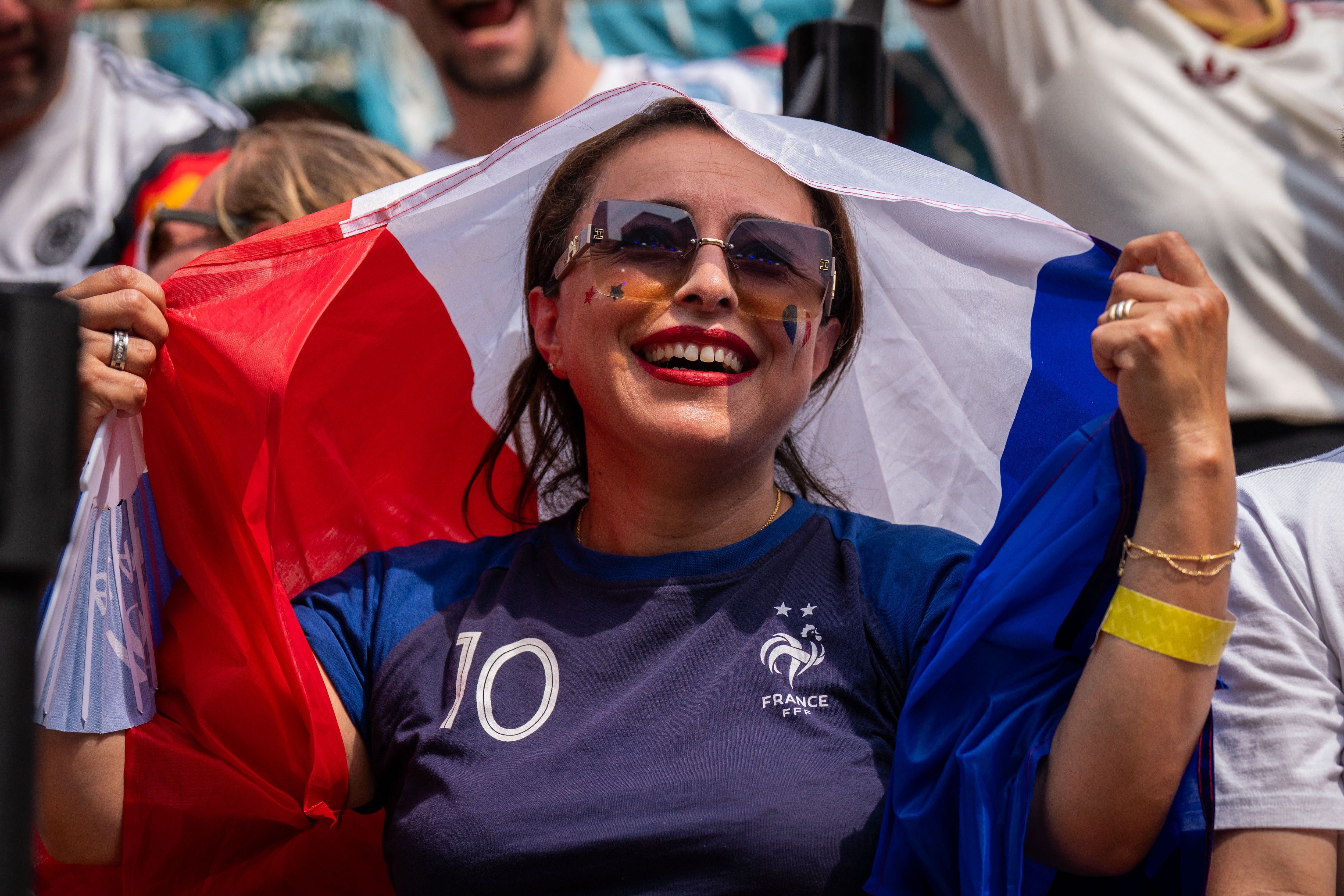 A French fan shields themselves from the sun during the World Cup semifinal soccer match between Spain and France at a watch party at the Rockefeller Center fan village, Tuesday, July 14, 2026