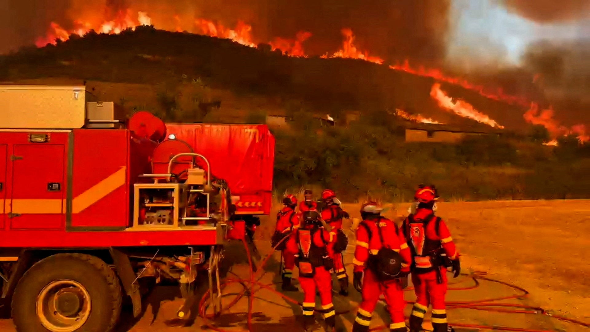 Firefighters work at a site following a wildfire in the municipality of Ores on Wednesday