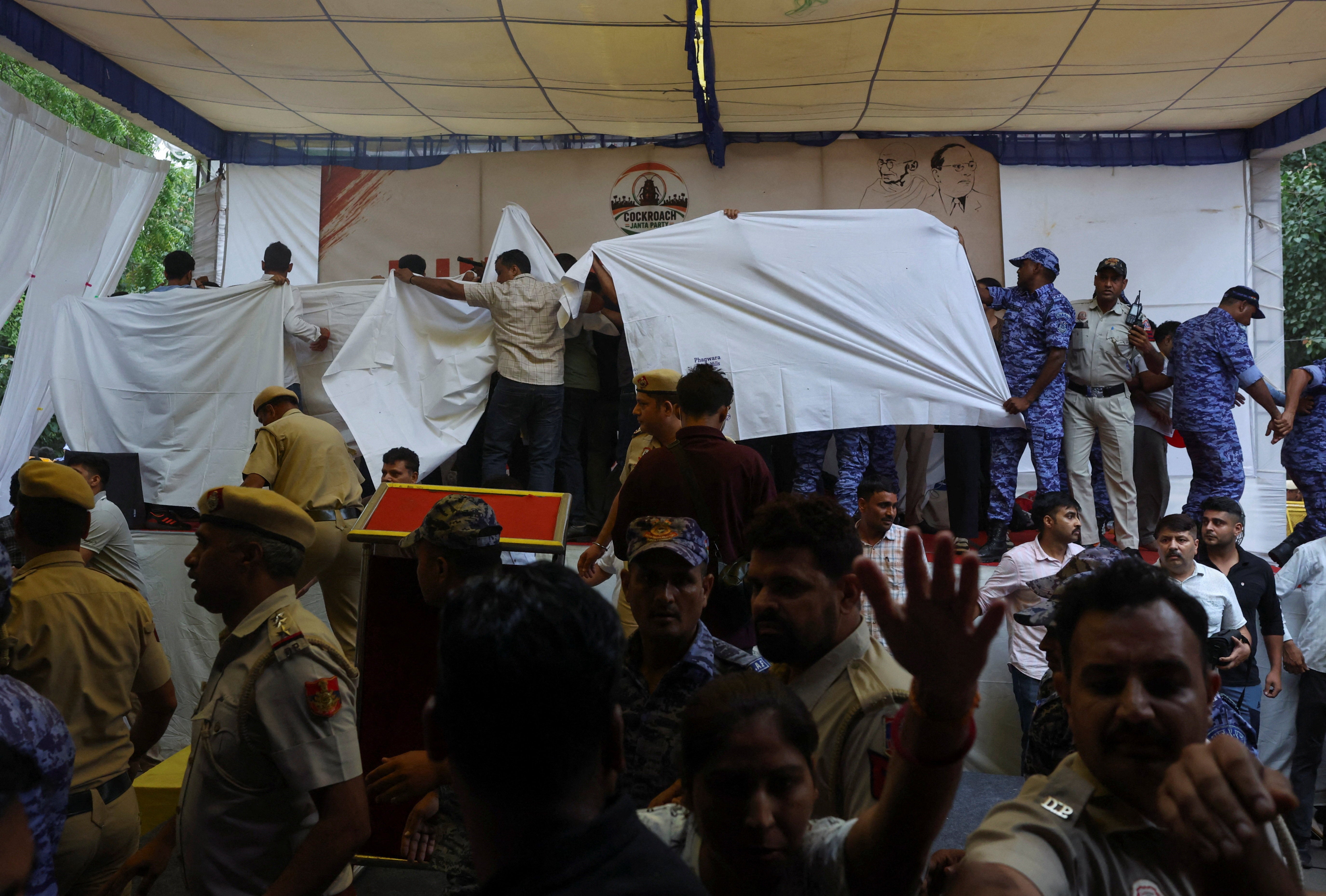 Authorities cover the stage with plain cloths as they prepare to take Sonam Wangchuk to the hospital during a sit-in protest called by Cockroach Janta Party
