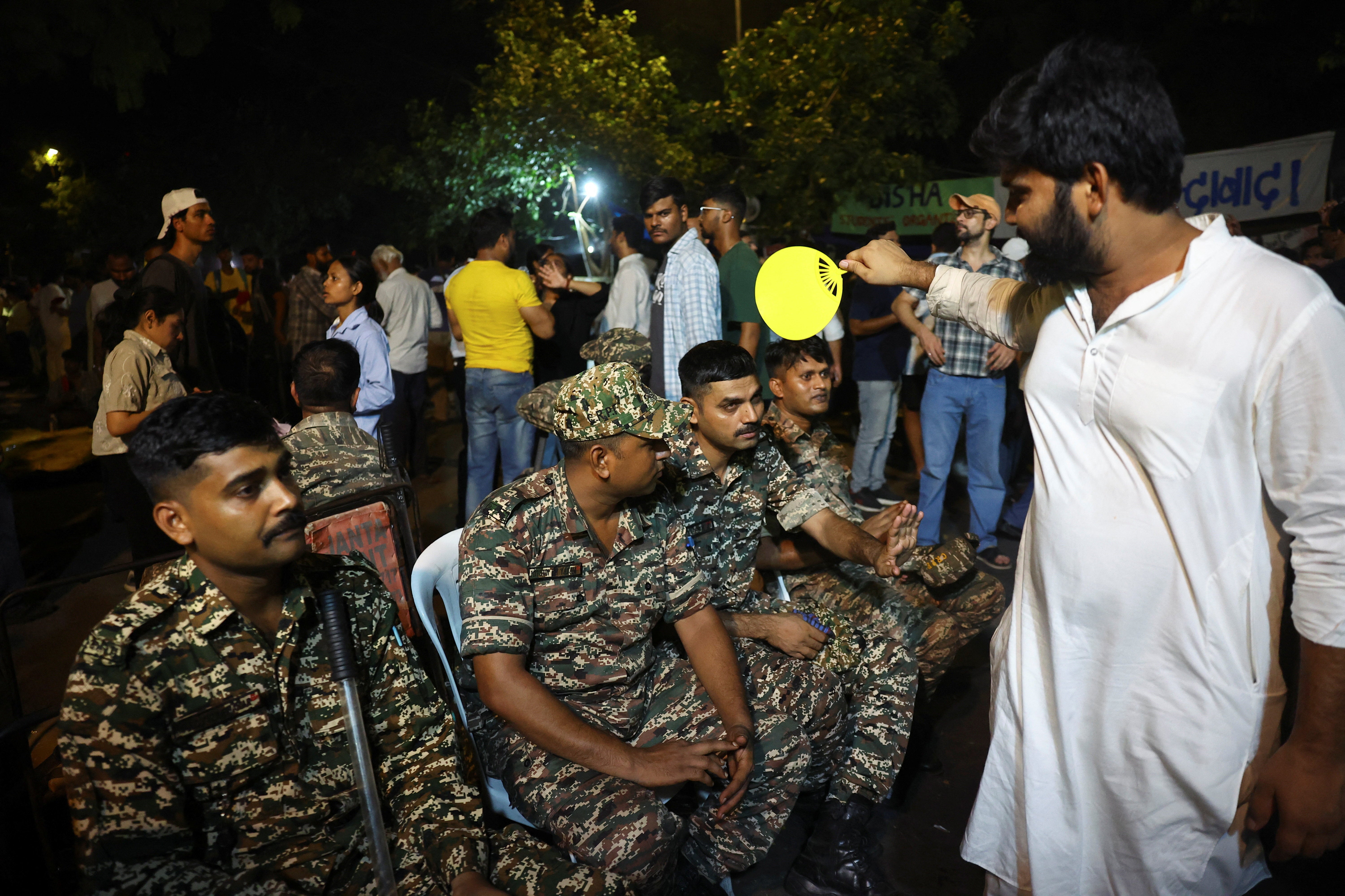 A supporter of the Cockroach Janta Party (CJP) fans members of the Central Reserve Police Force (CRPF)