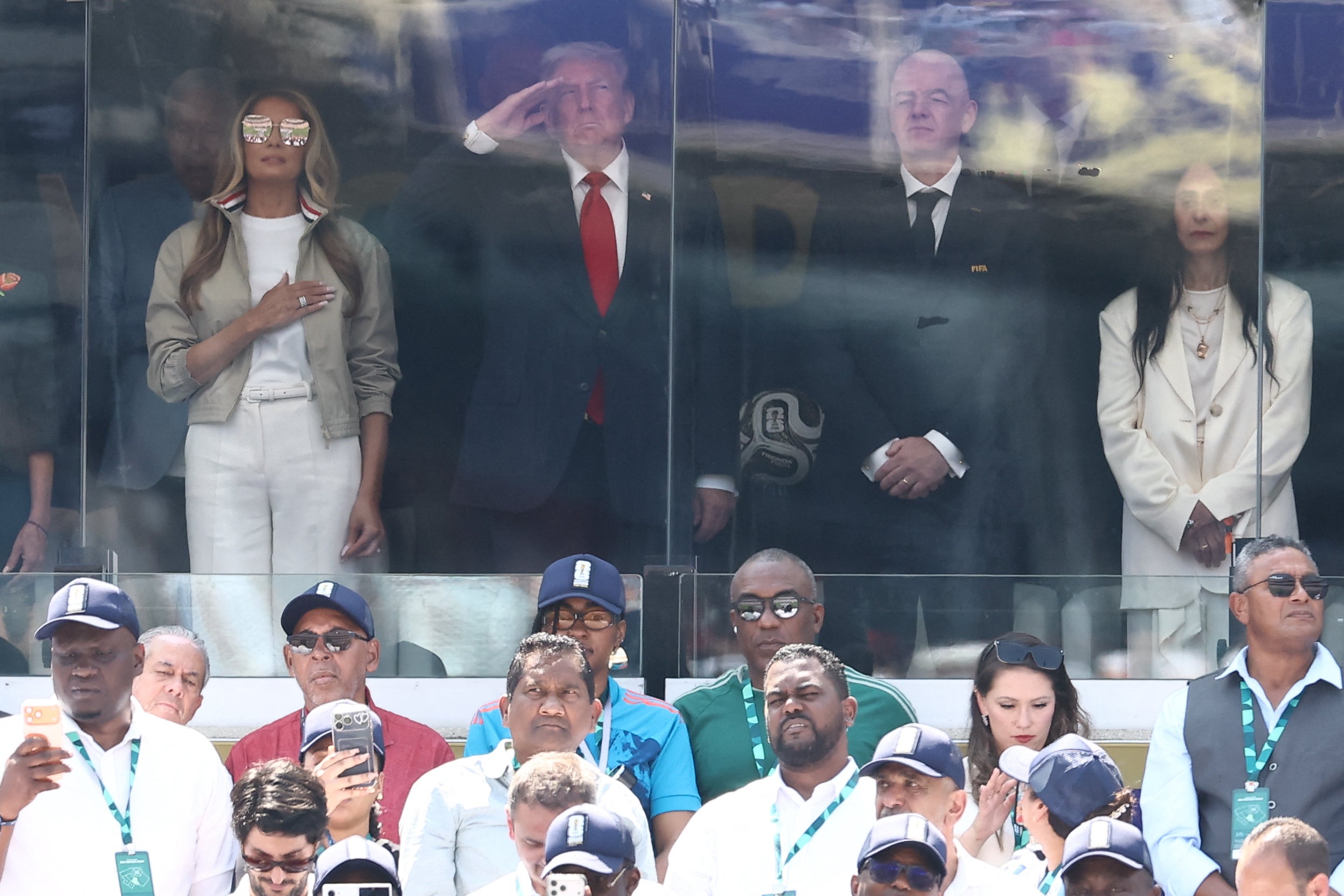 Trump, his wife Melania, and FIFA’s president listen to the National Anthem’s performance before Sunday’s game