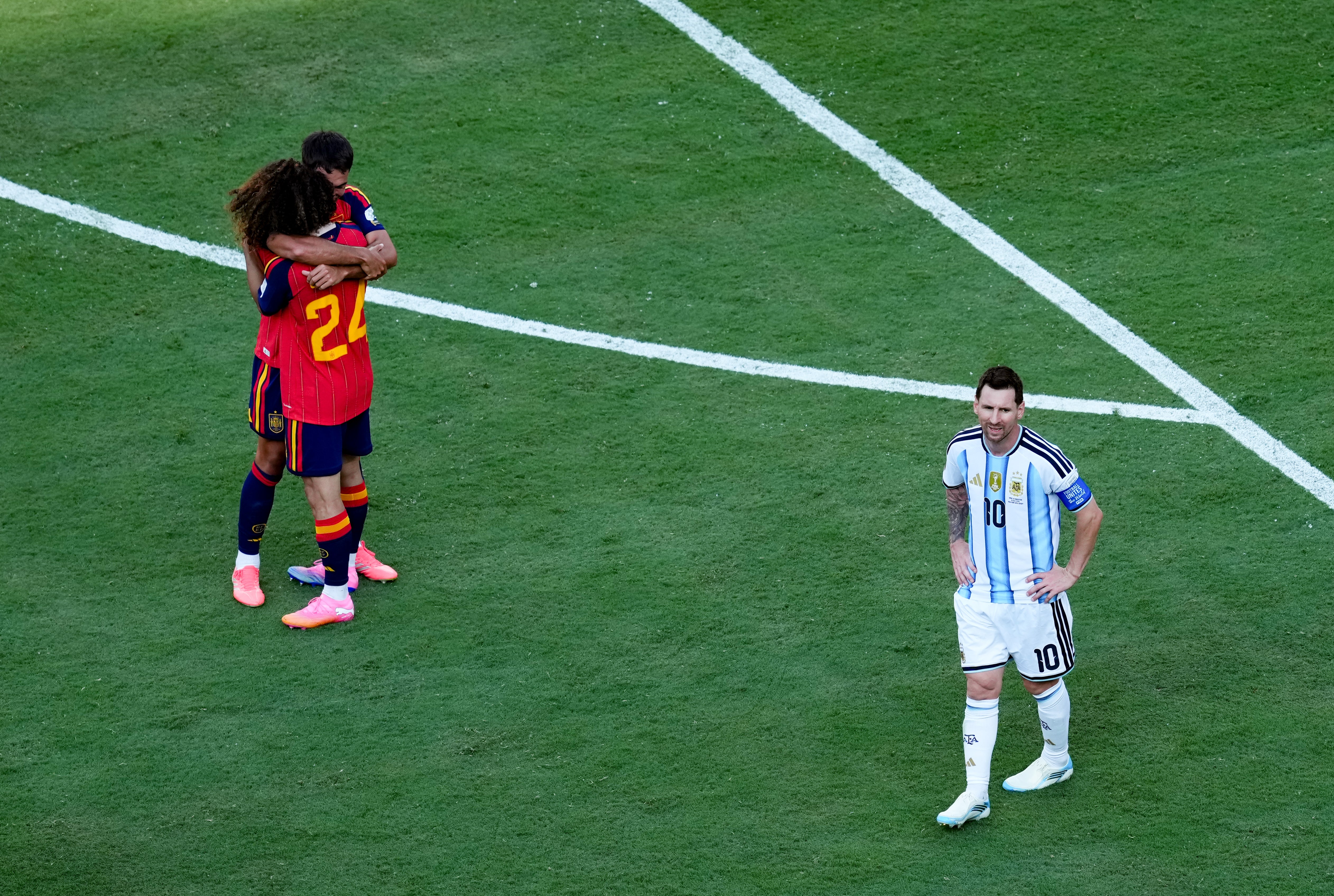 Argentina's Lionel Messi looks dejected as Spain players celebrate winning