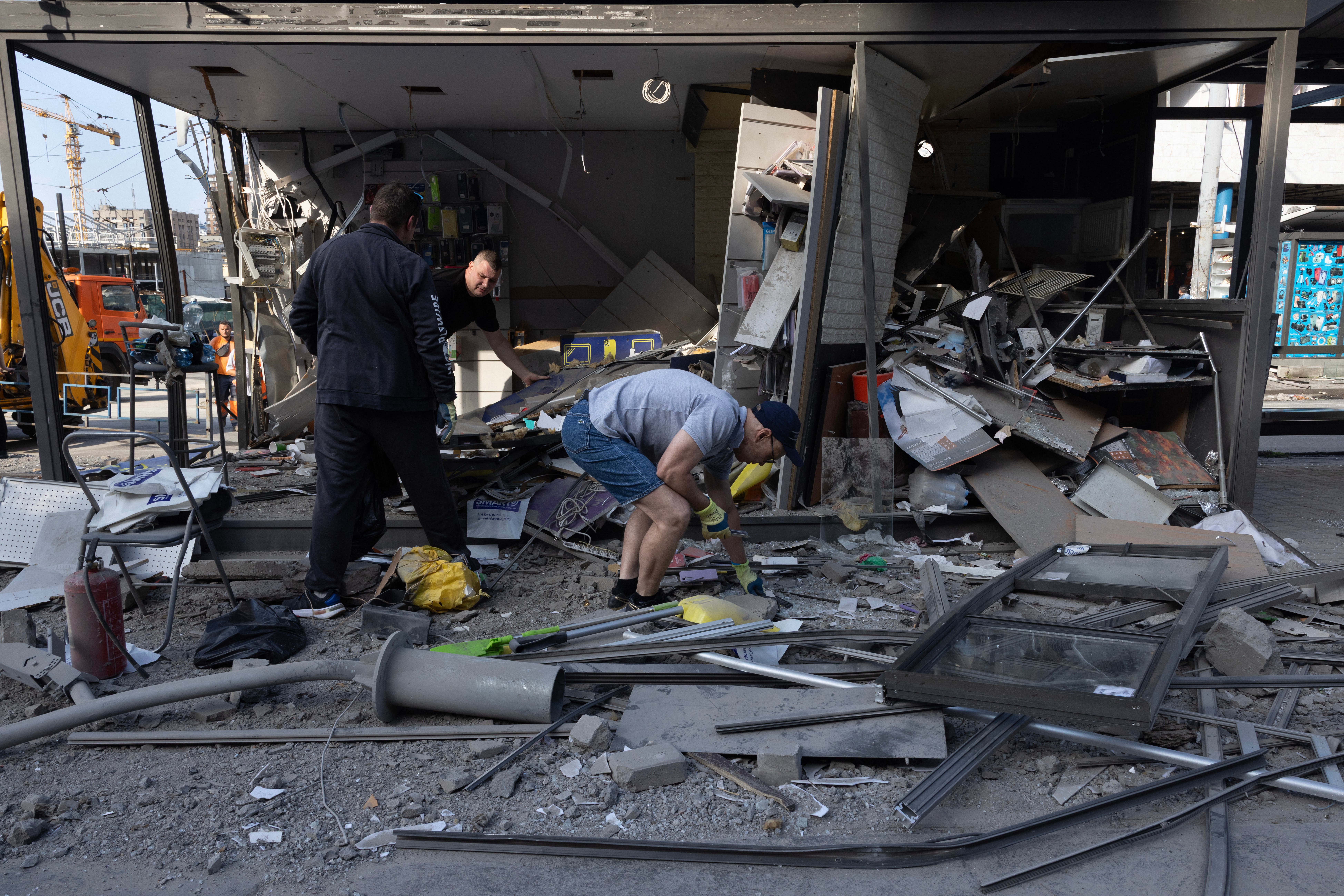 People clean up their small shop after a large-scale attack overnight that left at least one person dead and 14 injured