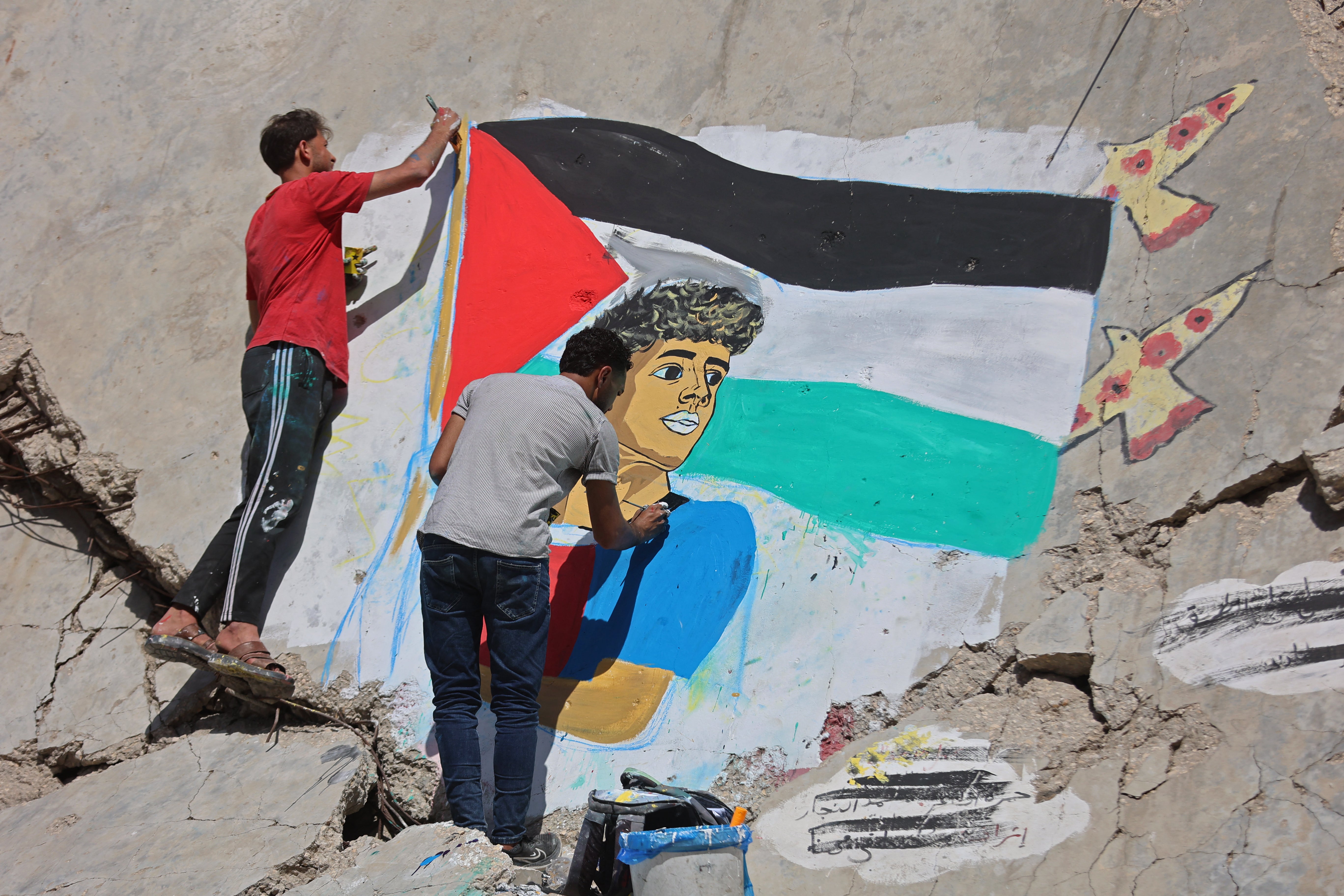 Palestinian artists paint a mural depicting football player Lamine Yamal waving a Palestinian flag during the Catalans' title parade, on the rubble of buildings destroyed during the war, at Shati (Beach) refugee camp in Gaza City on May 13, 2026.
