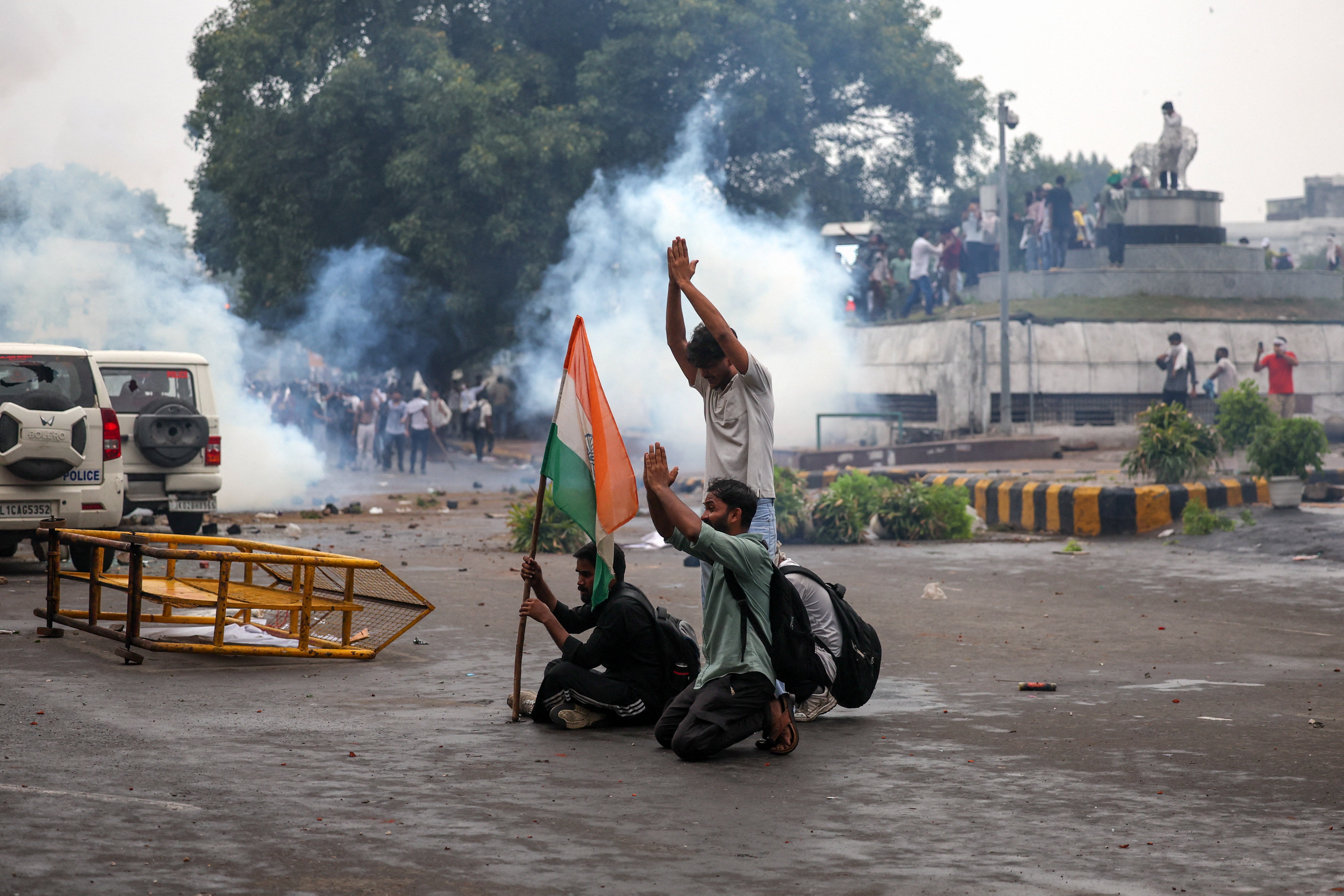 Protesters with an Indian flag gesture in request for the police not to use tear gas