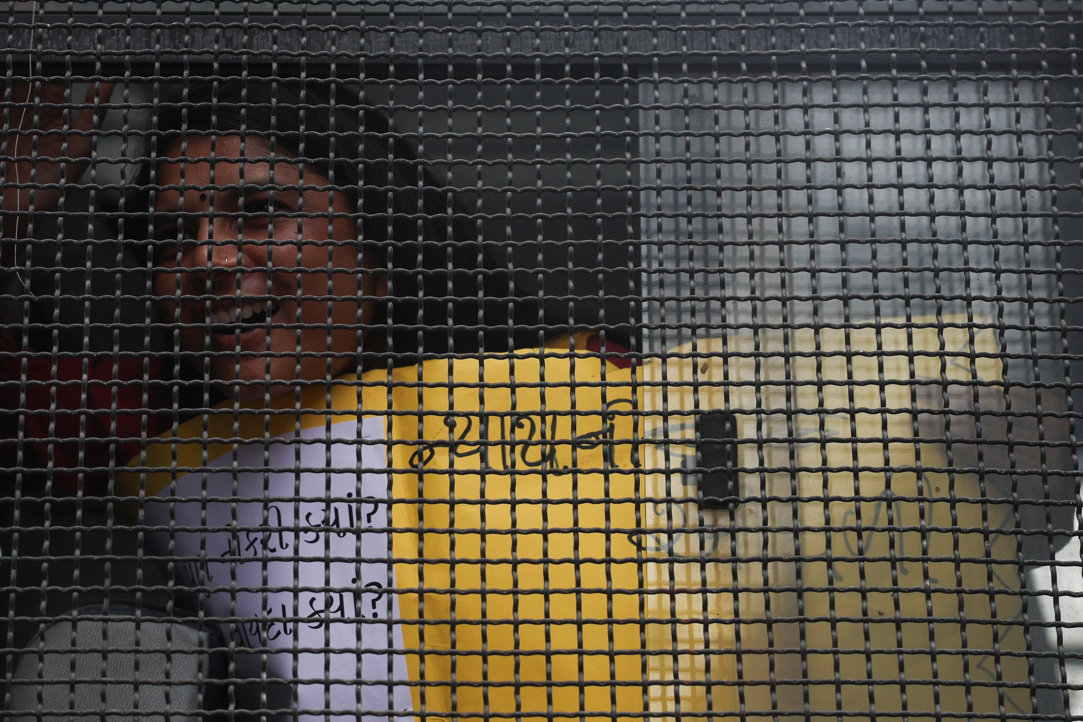 A detained protester shouts anti-government slogans from a police van