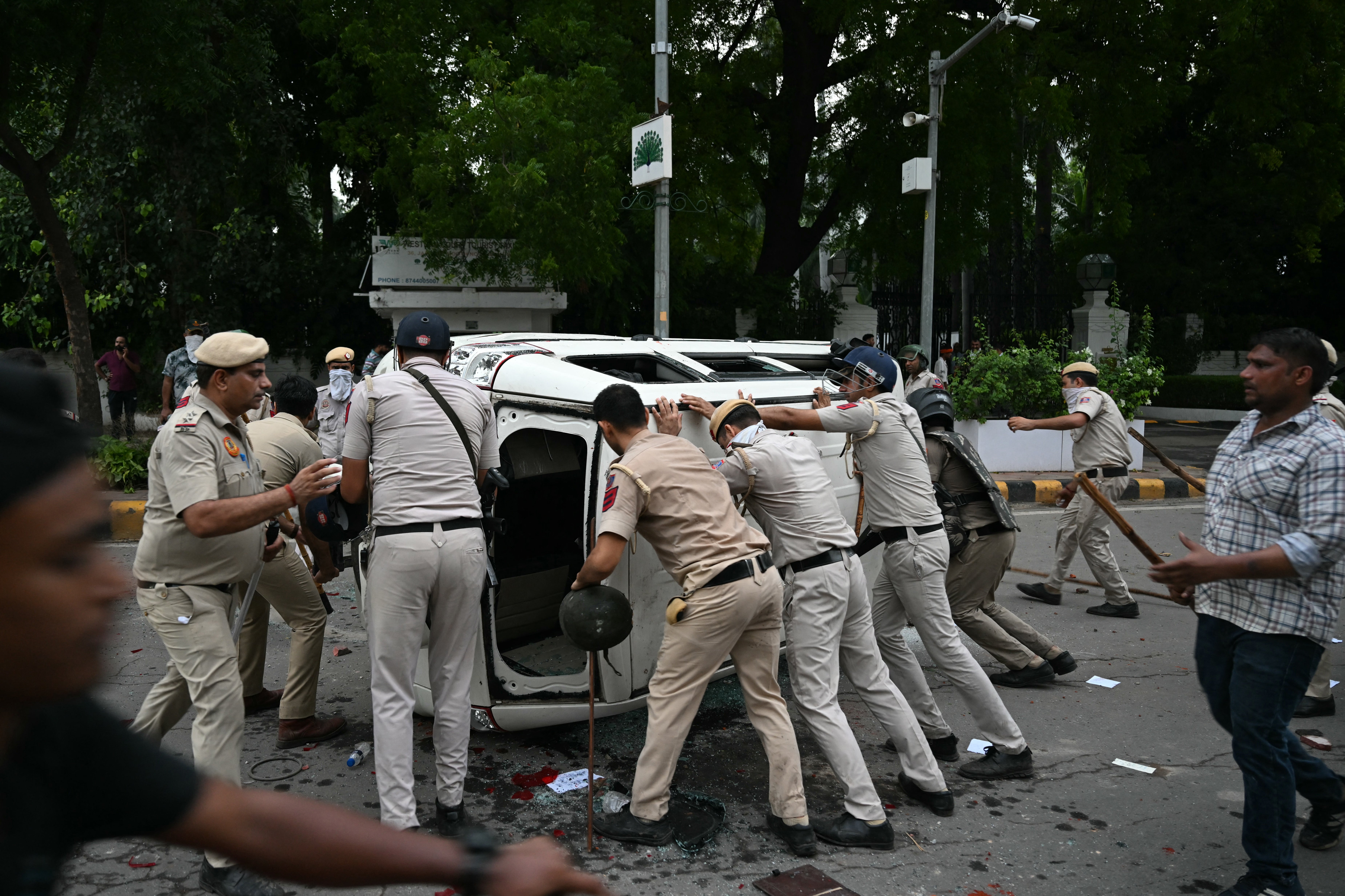 Police personnel turn over a damaged vehicle