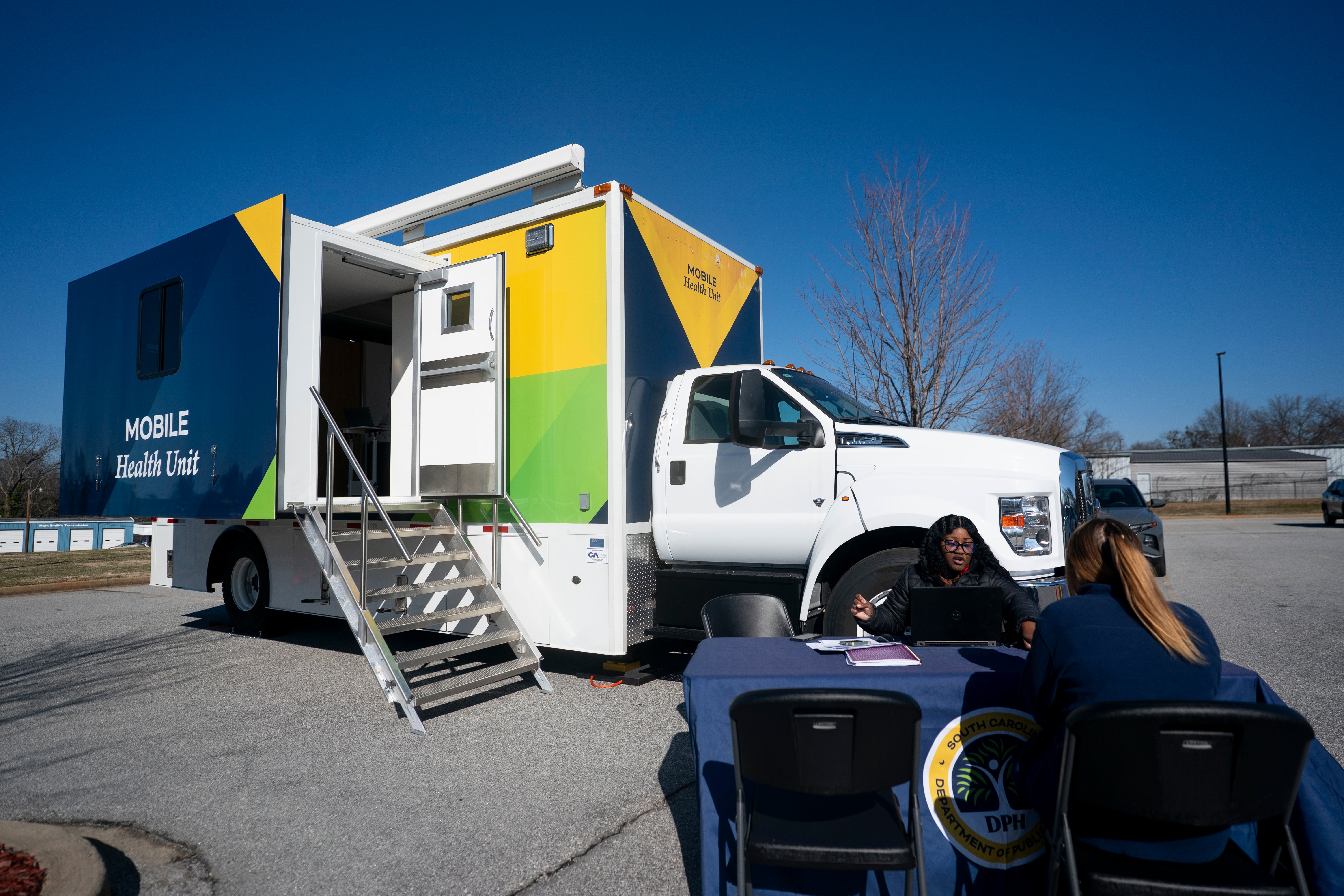 A worker with the South Carolina Department of Public Health talks to a patient outside a mobile vaccination clinic in February in Spartanburg, South Carolina. The state’s outbreak has ended
