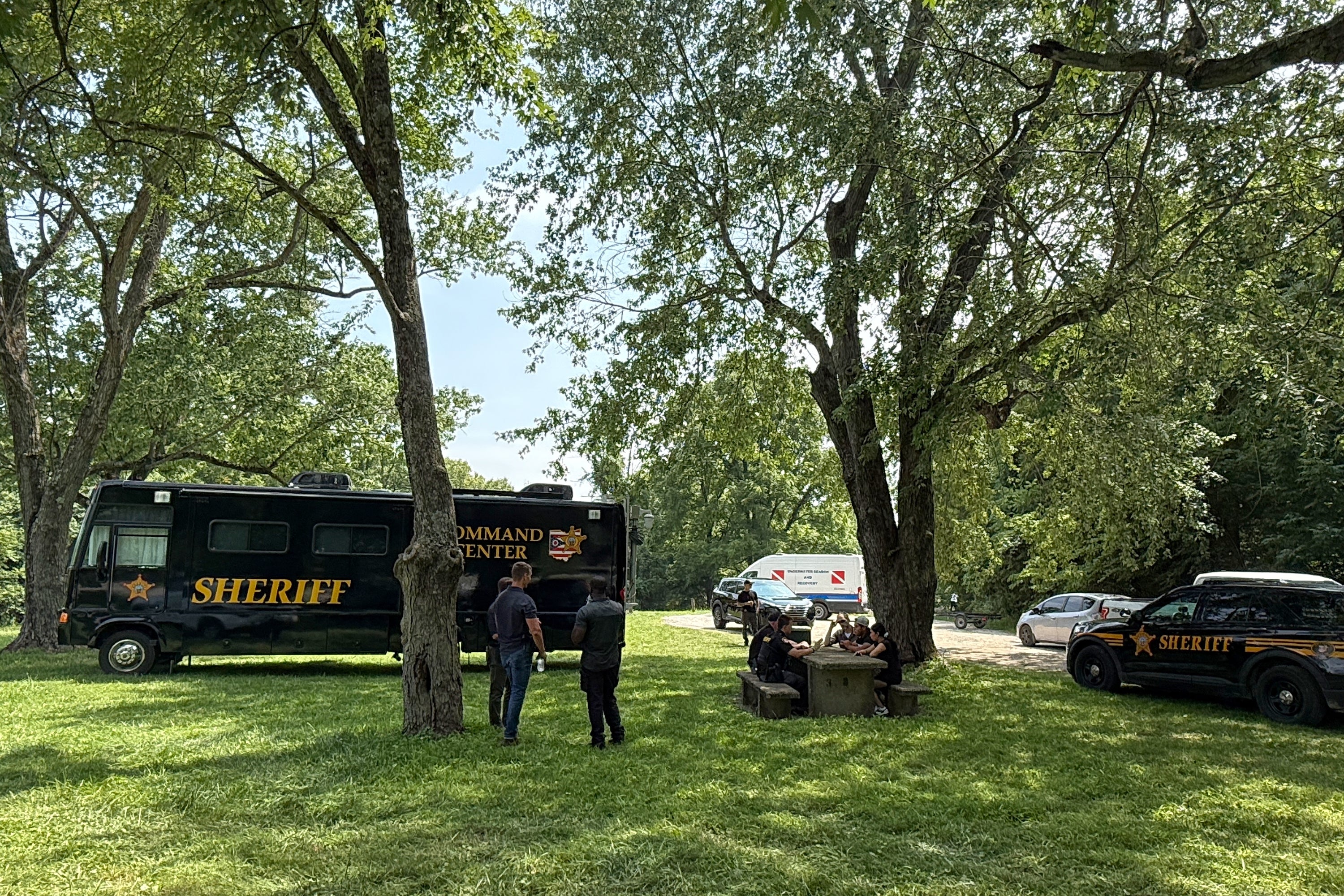 Officials stand at a staging area after an operation to recover multiple people who died while trying to save someone from the Scioto River in the Columbus suburb of Powell, Ohio, (AP)