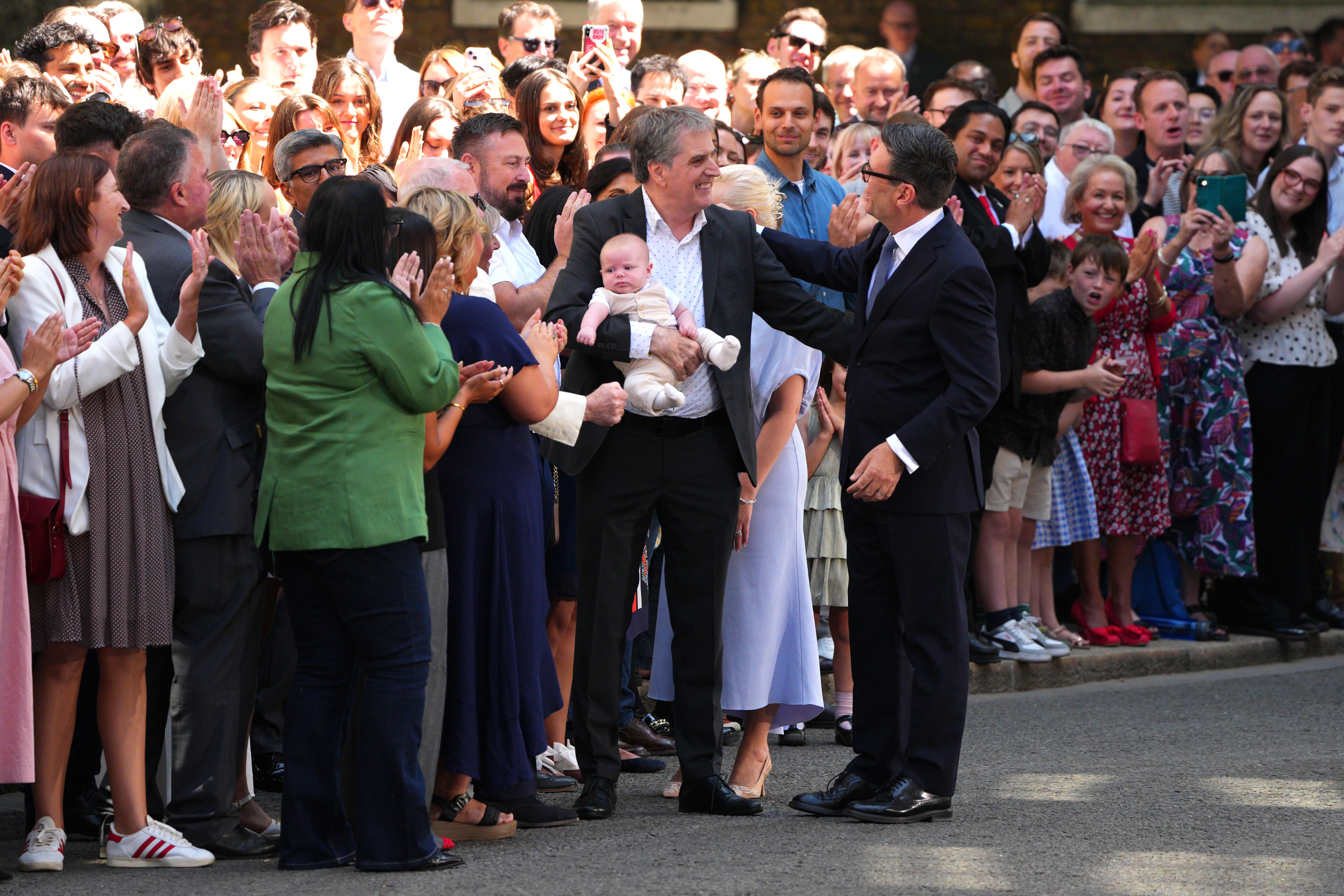 Andy Burnham, greets Mayor of the Liverpool City Region, Steve Rotheram and his grandson