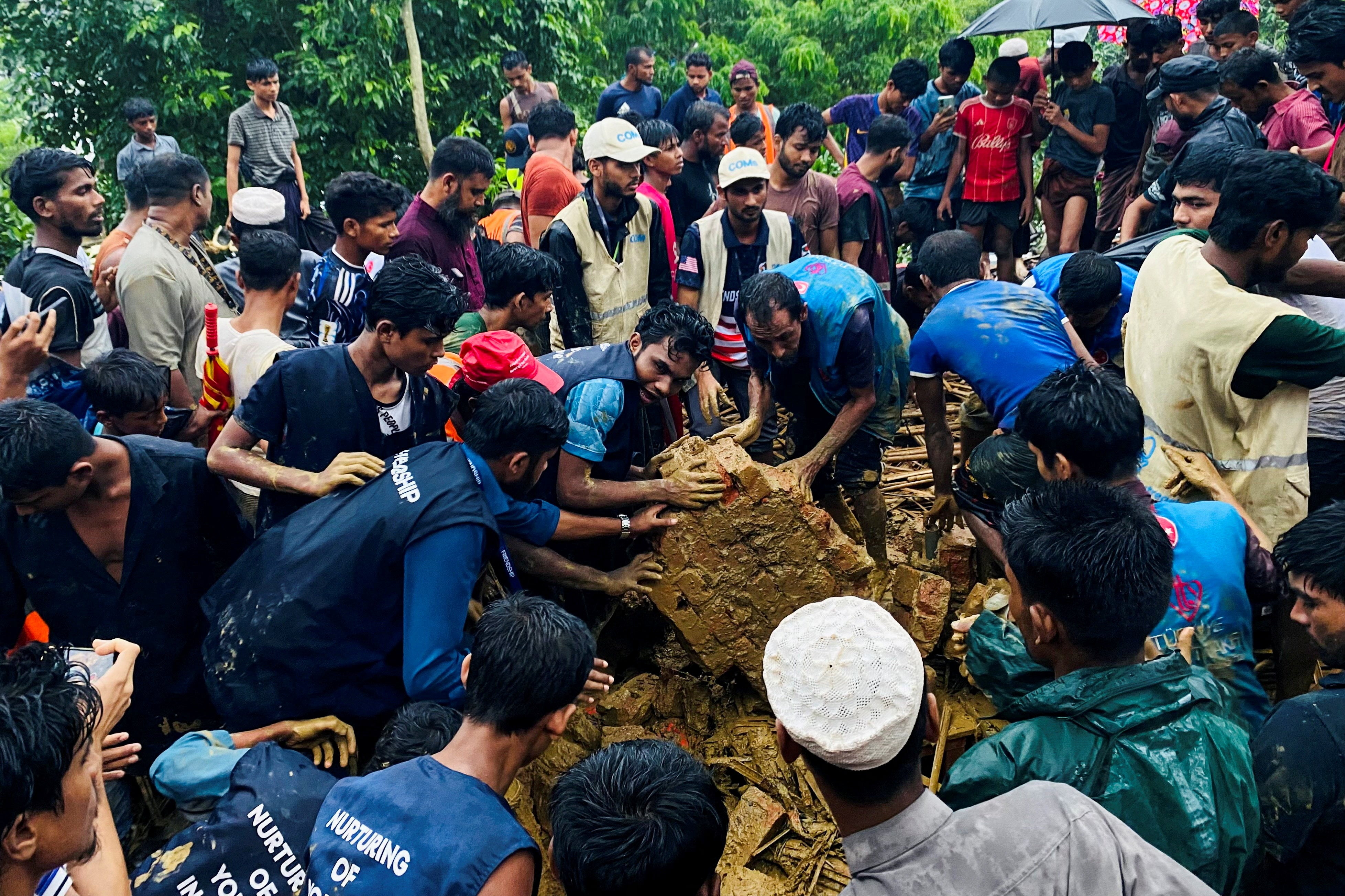 Rohingya refugees works to rescue victims from a landslide spot at a Rohingya Refugee Camp following continuous torrential rain, in Cox’s Bazar, Bangladesh, July 8, 2026