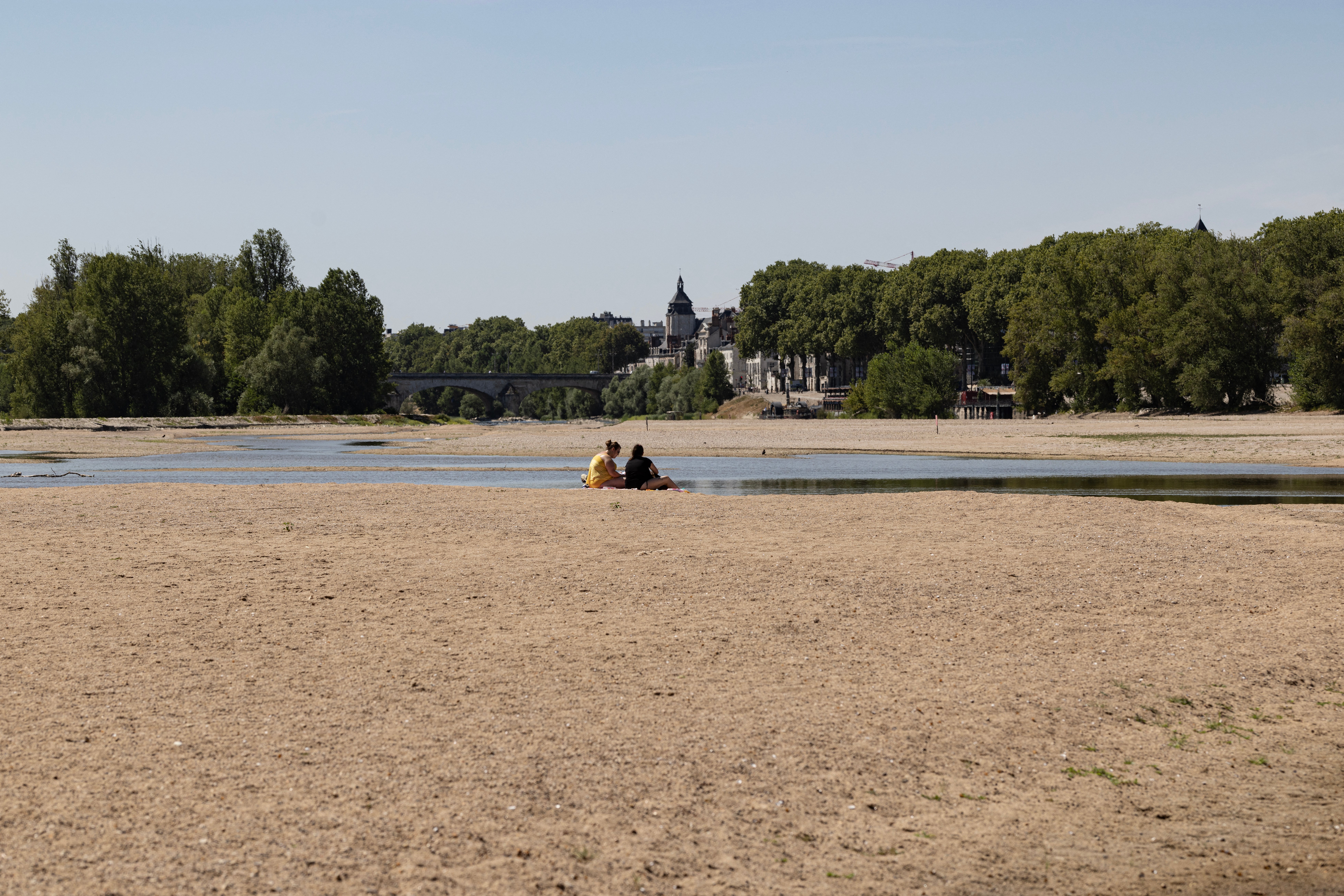 People enjoy the sun on the partially dry Loire riverbed