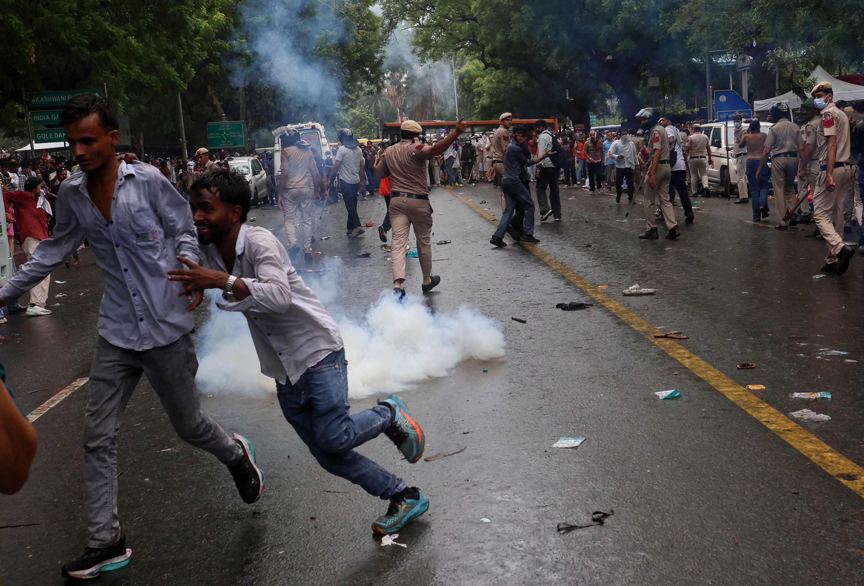 Protesters run as police use tear gas during clashes at a demonstration organised by CJP