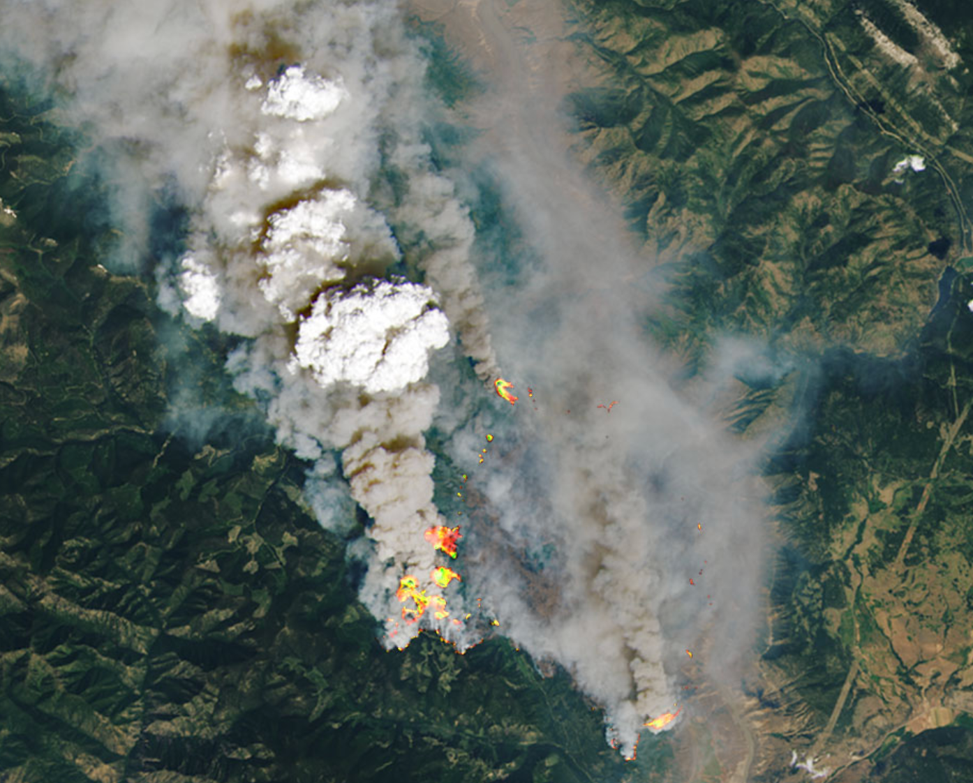 White pyrocumulonimbus clouds generated by the 2021 McKay Creek fire in British Columbia are seen in this NASA satellite image