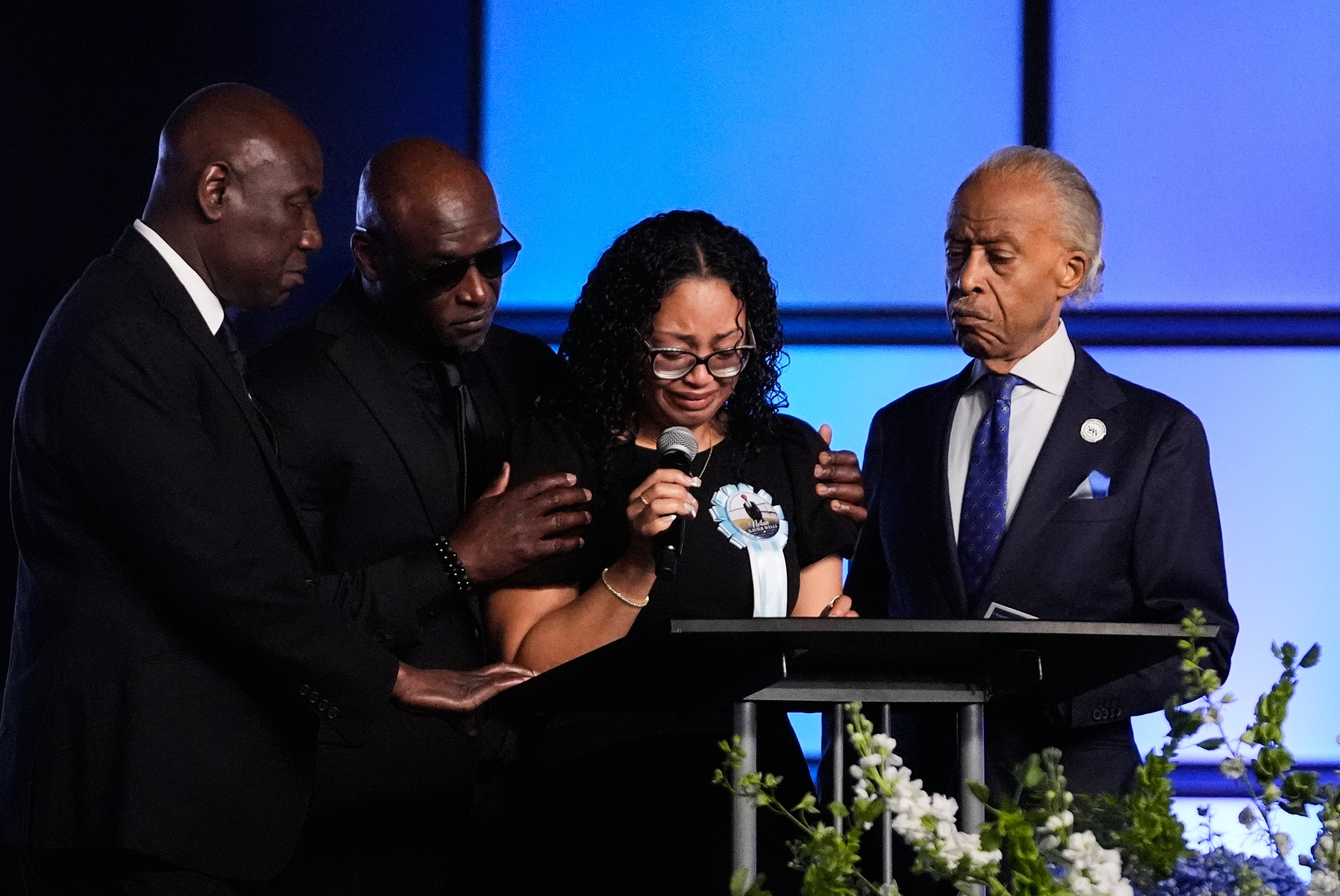 Christine Wonsley is flanked by her husband Elmore, attorney Ben Crump and Rev, Al Sharpton during the service