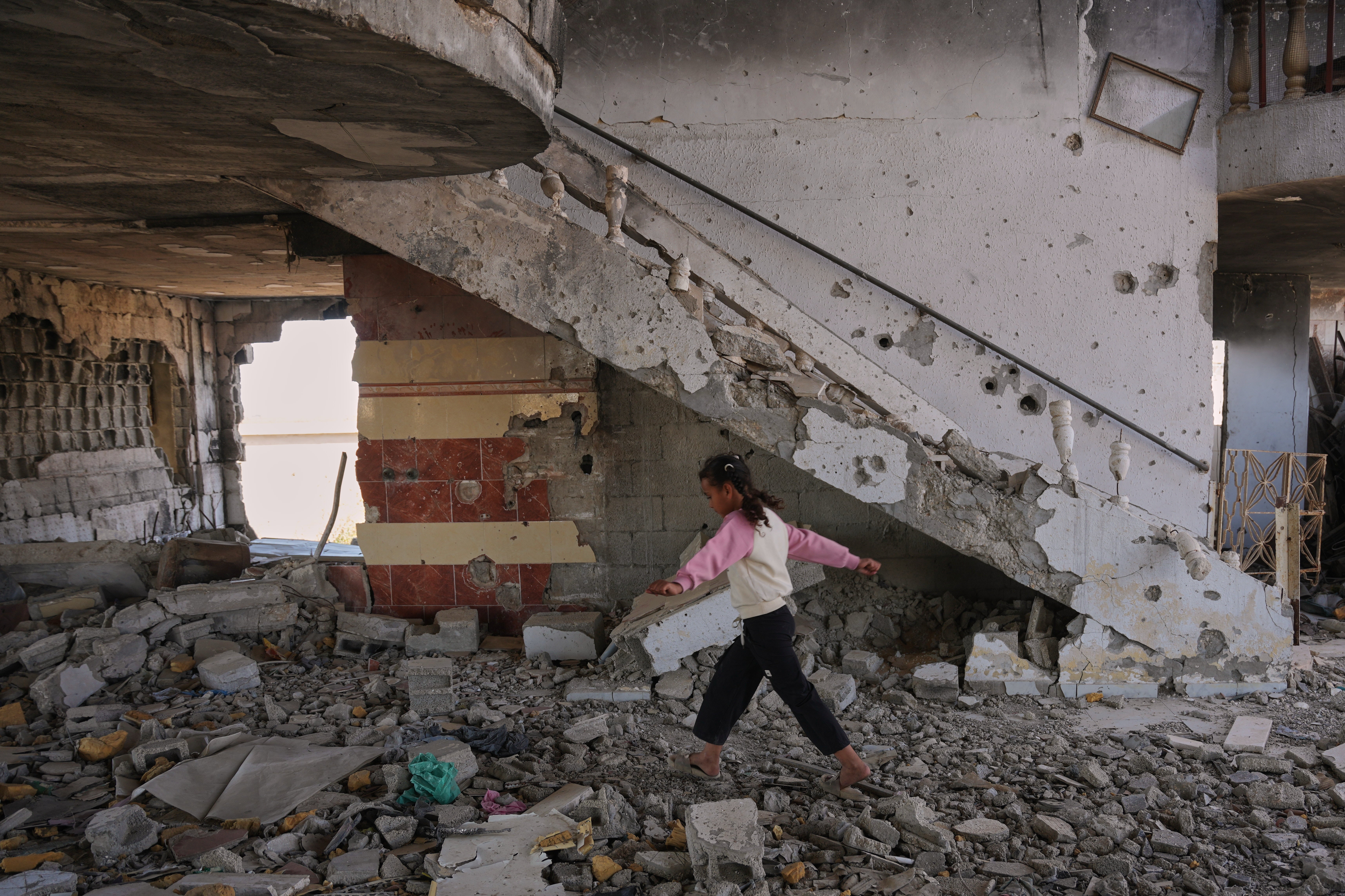 Arjwan al-Gharam walks over debris inside her home after it was damaged during the Israel-Hamas war in Nuseirat, central Gaza Strip, Thursday, June 4, 2026. (AP Photo)
