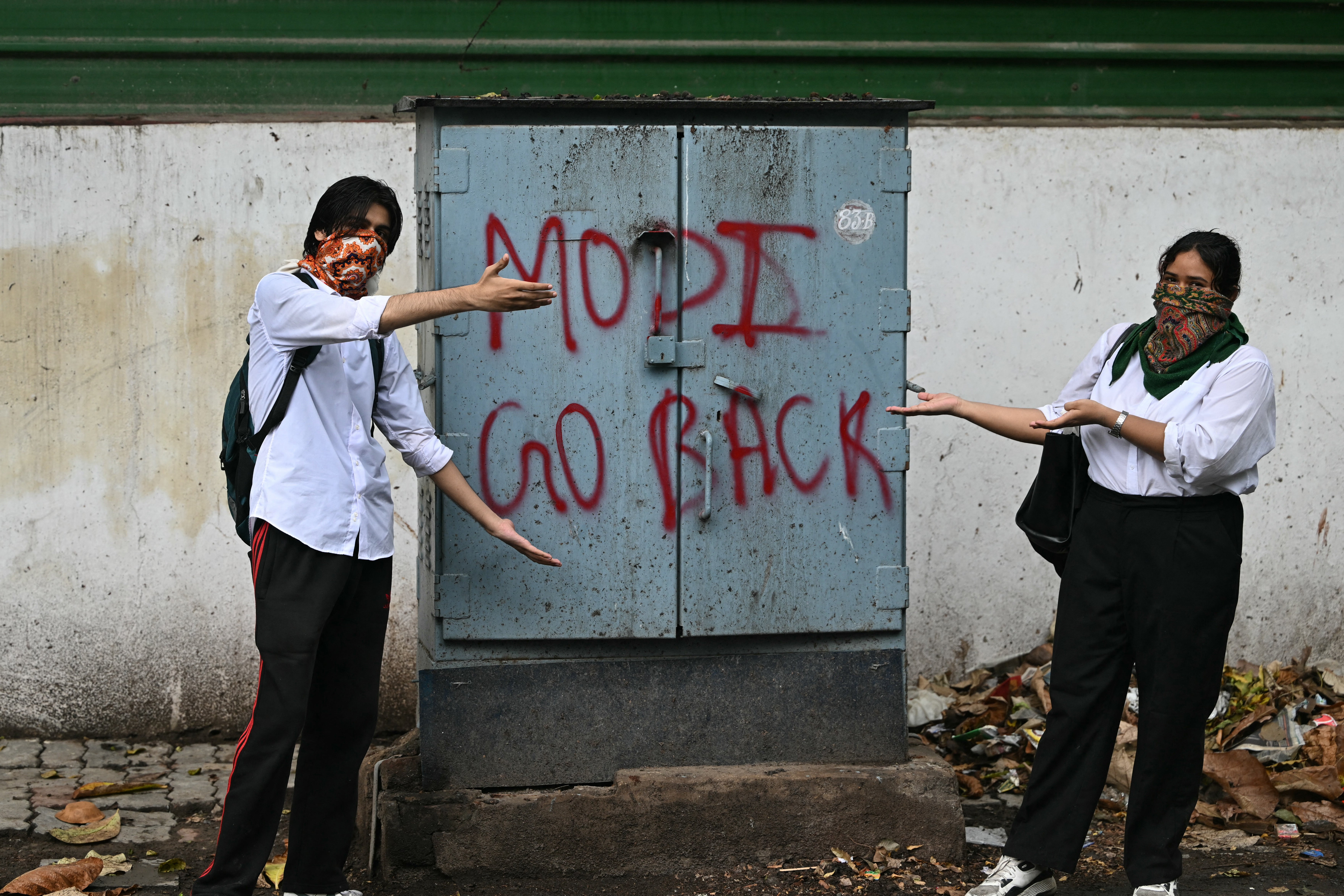 Supporters of the Cockroach Janta Party (CJP) pose next to a message along a street after clashing with police (AFP/Getty)