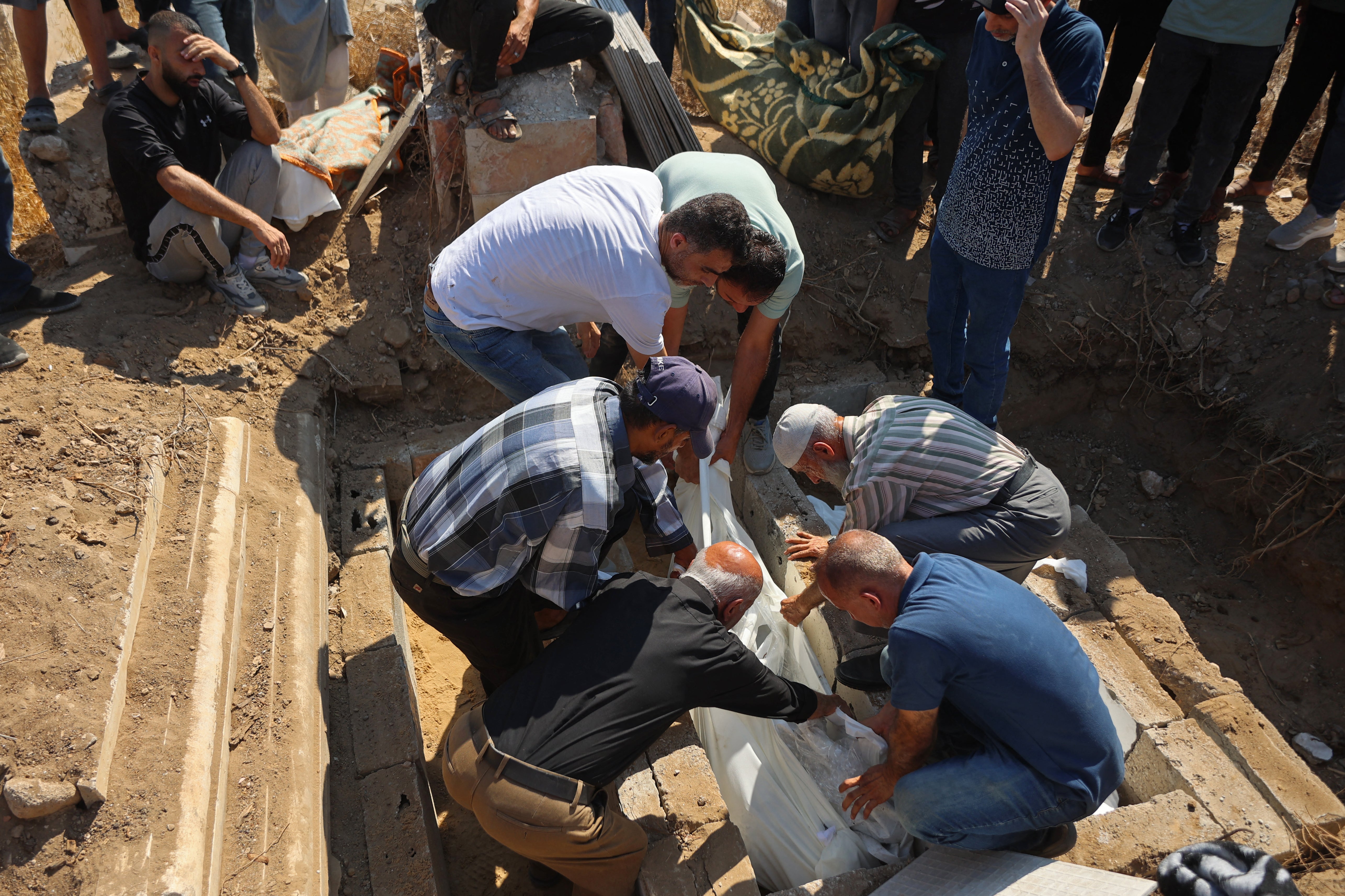Family members conduct the burial ceremony for the Palestinians who died after an Israeli airstrike targeted a residential apartment in the Sabra neighborhood of Gaza City on July 21, 2026