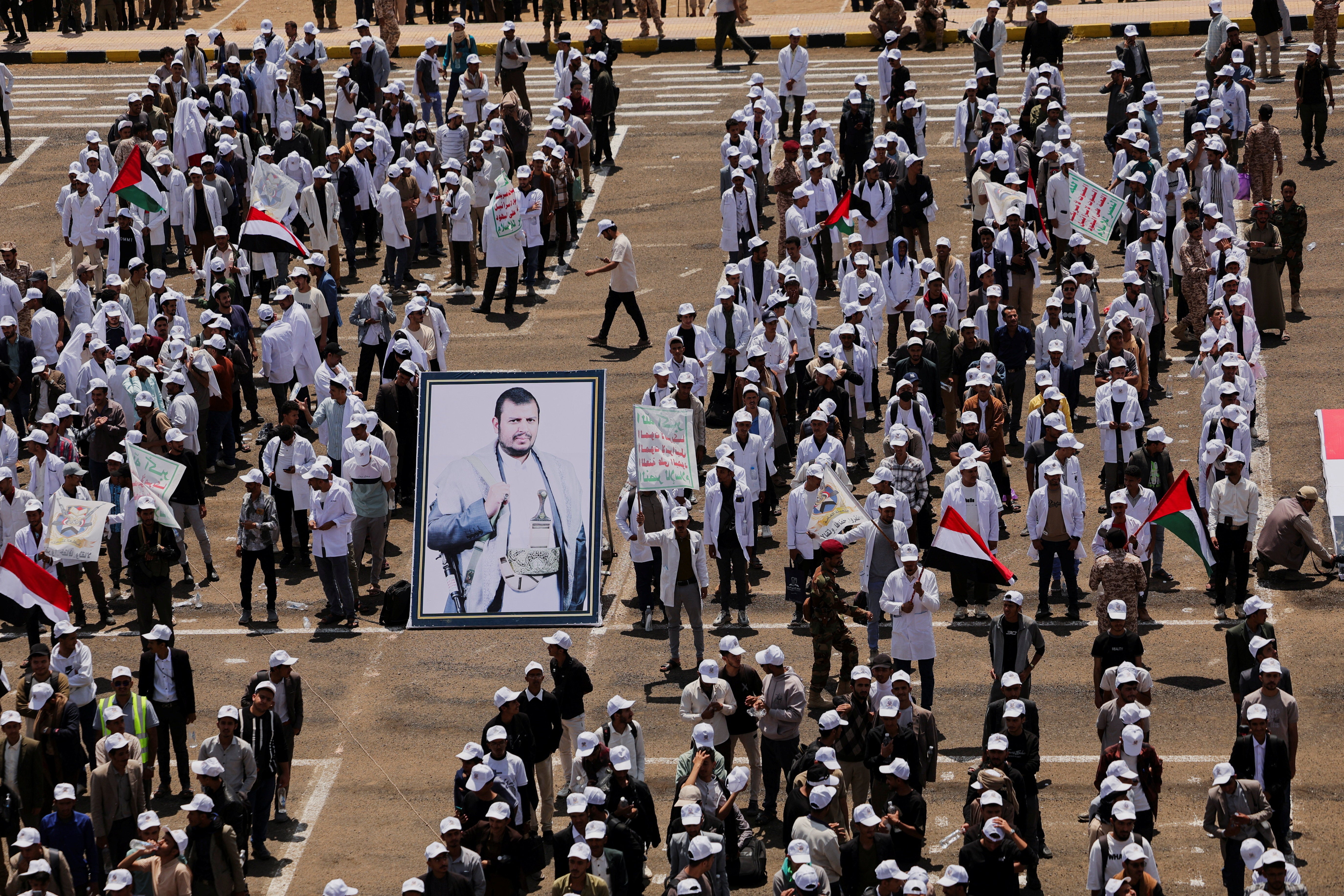 Students stand by a poster of Houthi leader Abdul-Malik al-Houthi as they parade (Reuters)