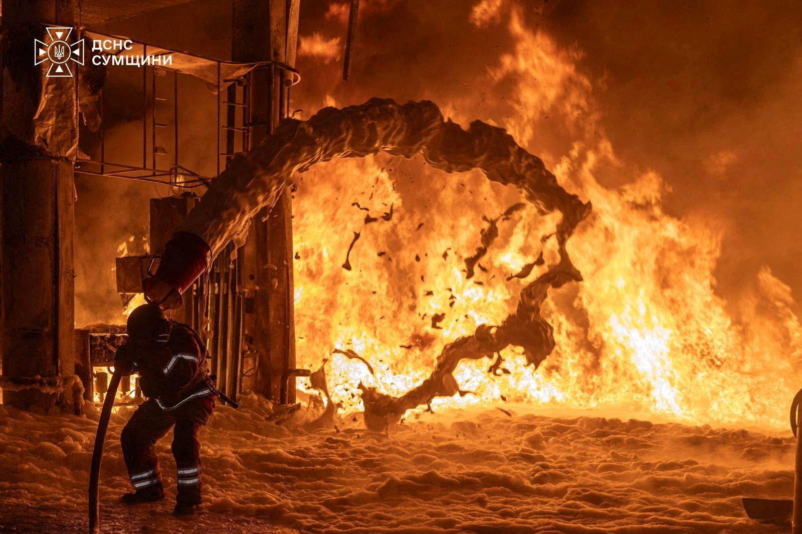 A firefighter works at the site of a petrol station hit by a Russian drone strike, 23 July