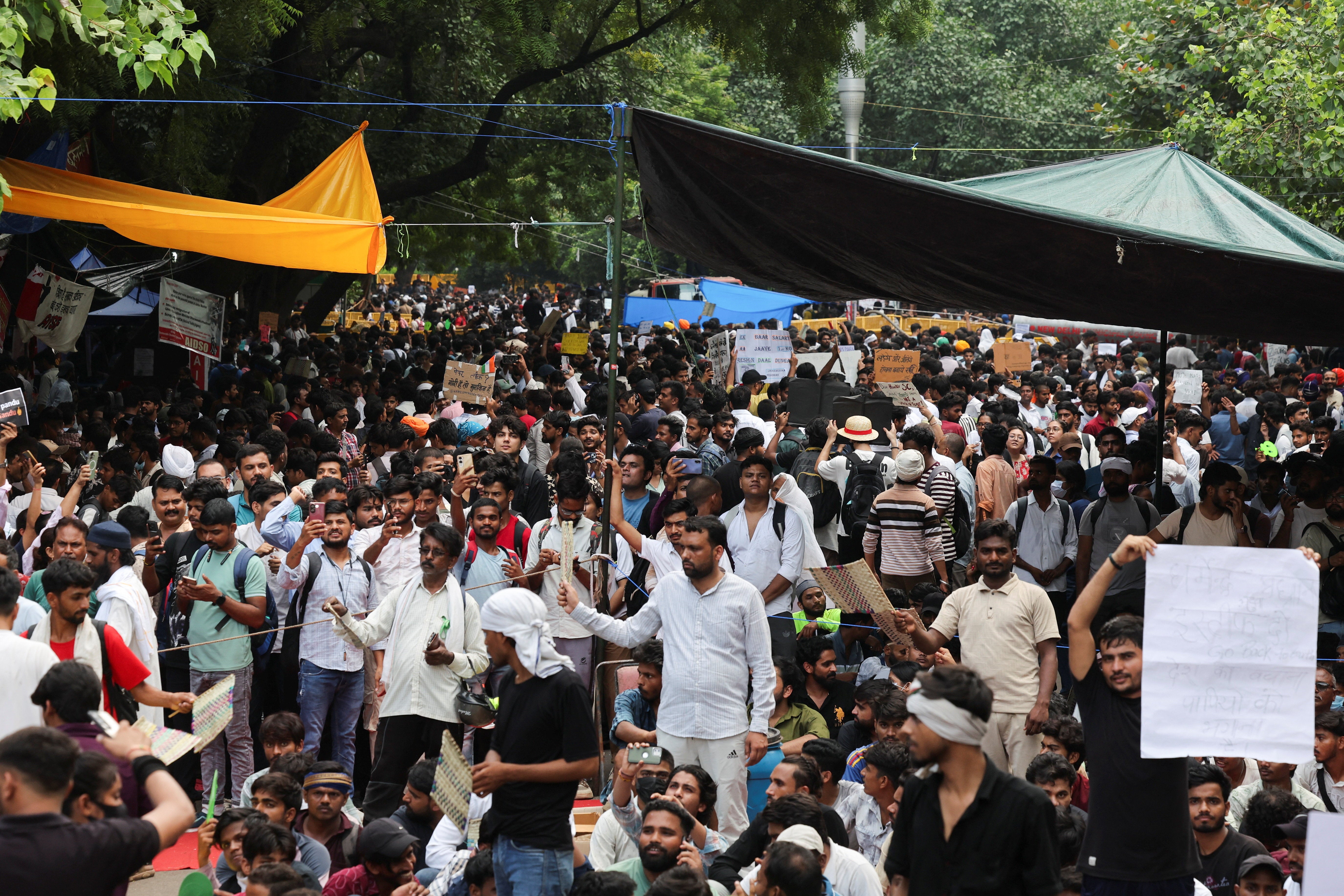 Supporters of India's Cockroach Janata Party (CJP) hold signs during the ongoing protests, a few days after thousands of protesters marched towards parliament demanding the resignation