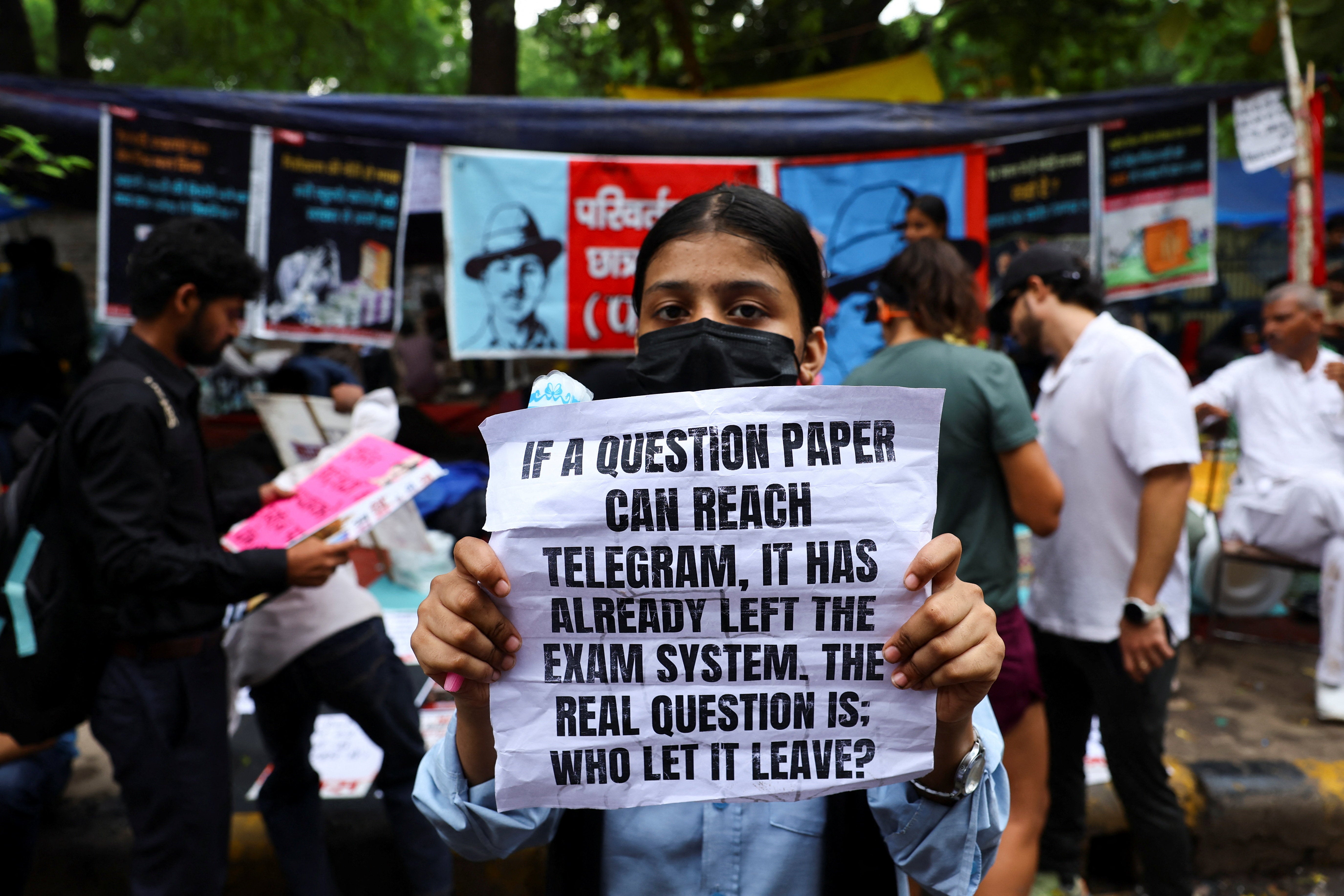 A supporter of India's Cockroach Janata Party (CJP) holds a sign during the ongoing protests, a few days after thousands of protesters marched towards parliament