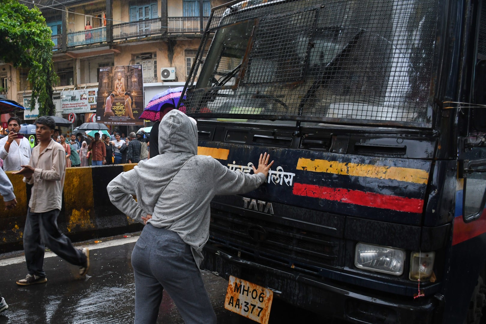 Rhiya Ahir, a model, blocks a police van carrying detained protesters during a demonstration demanding educational reforms as part of the Cockroach Janta Party's ongoing protest movement in Mumbai, India
