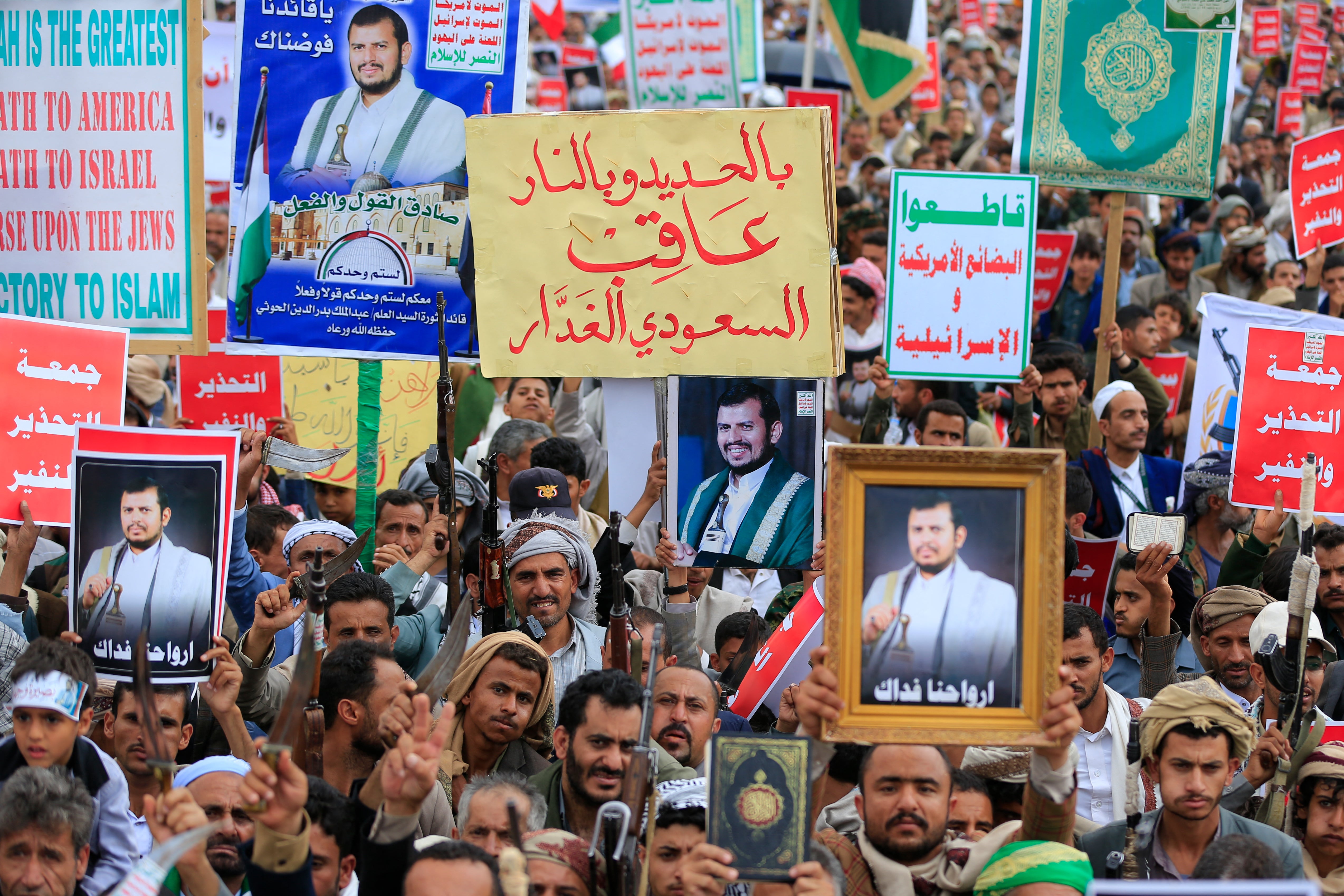 Apoiadores iemenitas armados do movimento Houthi, apoiado pelo Irã, seguram retratos do líder Houthi, Abdul-Malik al-Houthi, enquanto protestam contra as restrições impostas pela coalizão liderada pela Arábia Saudita nas áreas controladas pelos Houthi no Iêmen.